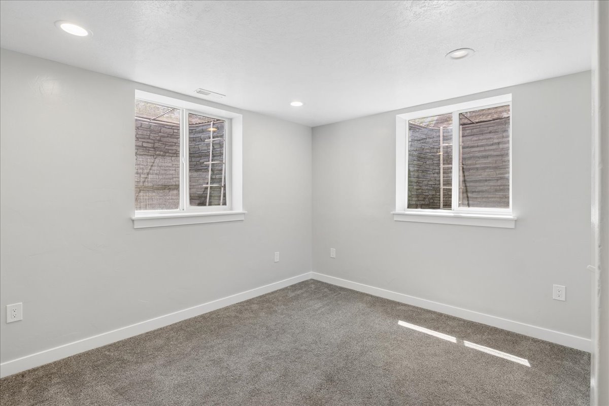 Room featuring recessed ceiling lighting, light gray wall paint, white baseboards, and gray textured carpeting