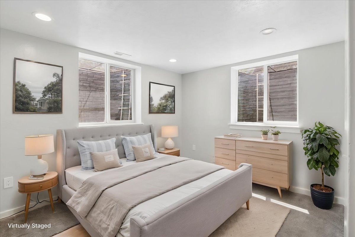 Recessed lighting illuminates this room featuring light-colored walls and carpeted flooring