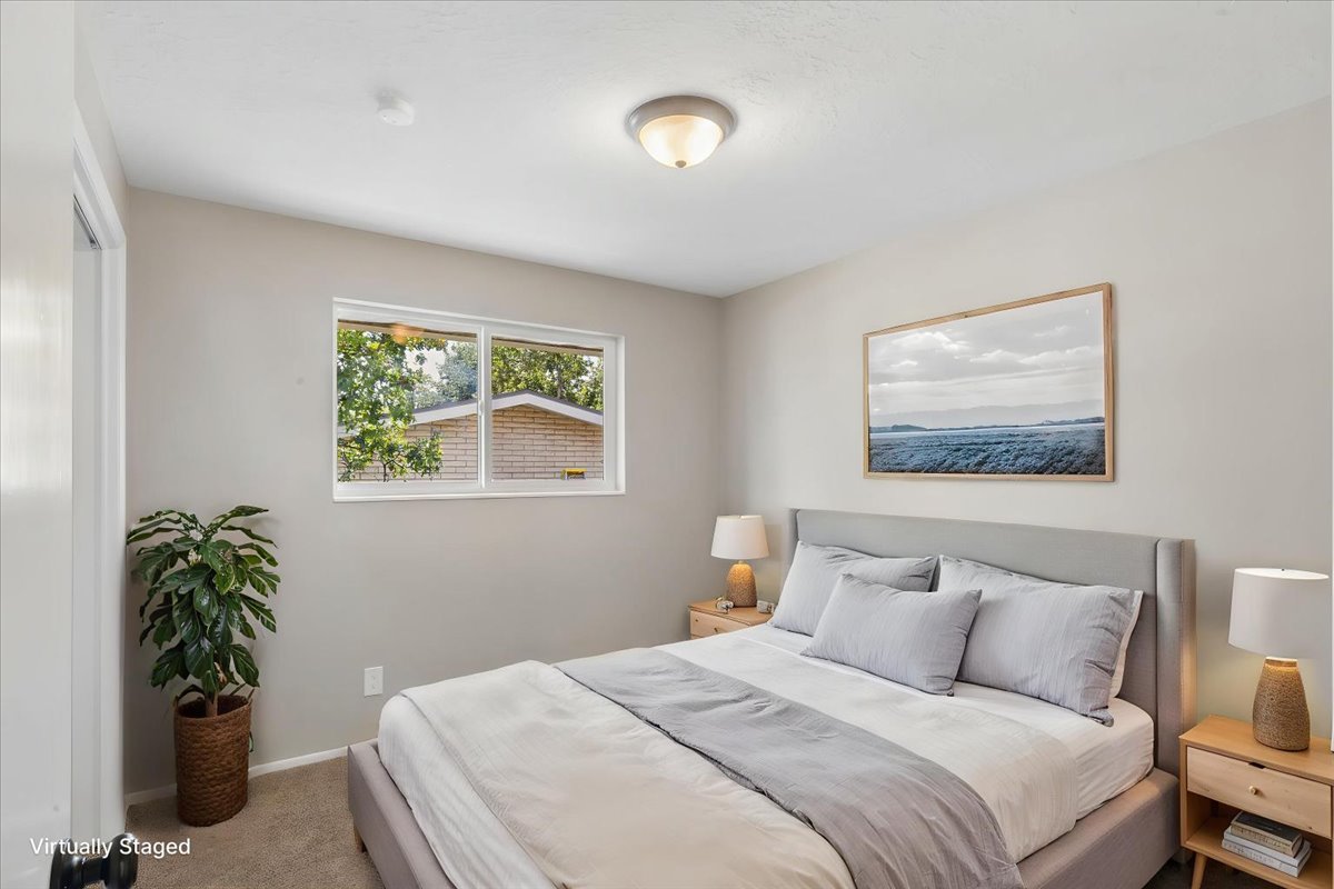 Bedroom featuring neutral-toned walls, carpeted flooring, a double-pane window, and a ceiling-mounted light fixture