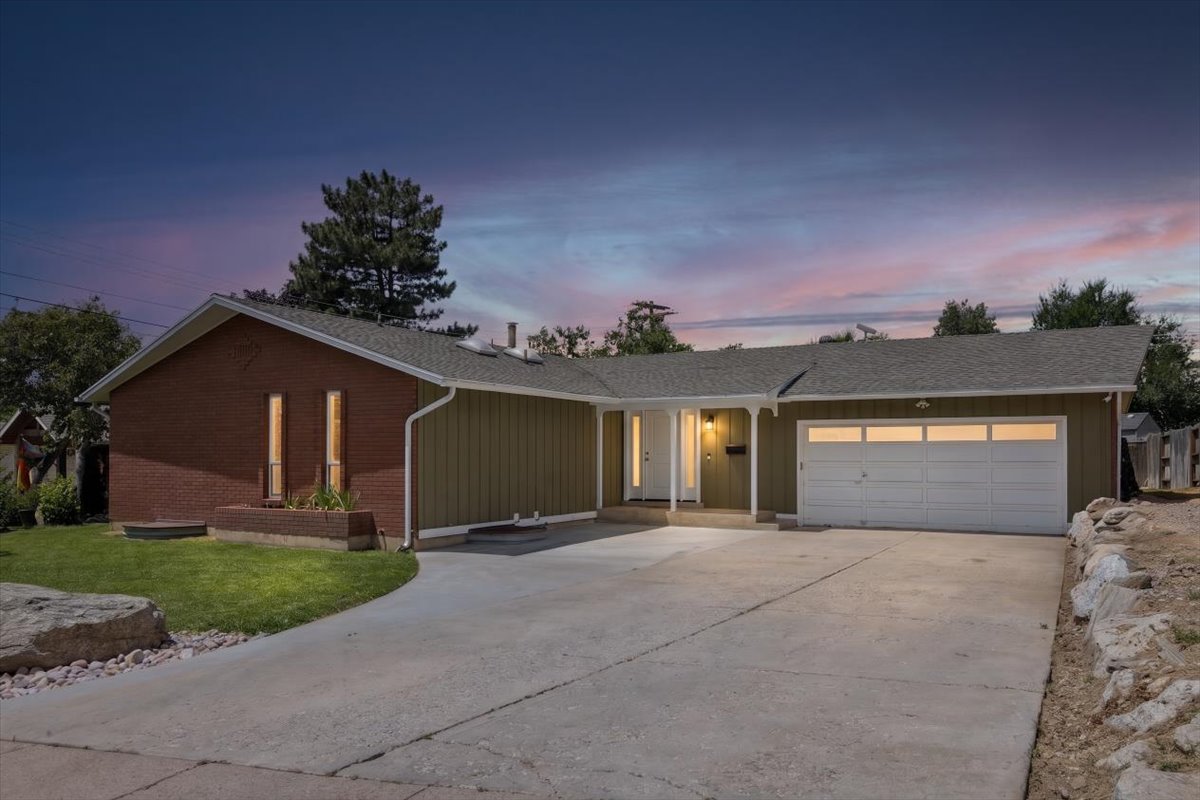 Single-story residence featuring a brick and siding exterior, a two-car garage with transom windows, and a paved driveway