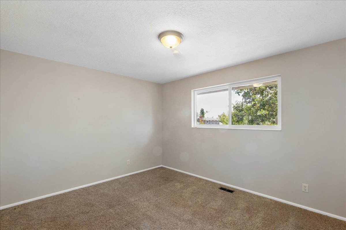 Neutral-toned walls complement the brown carpeted flooring
