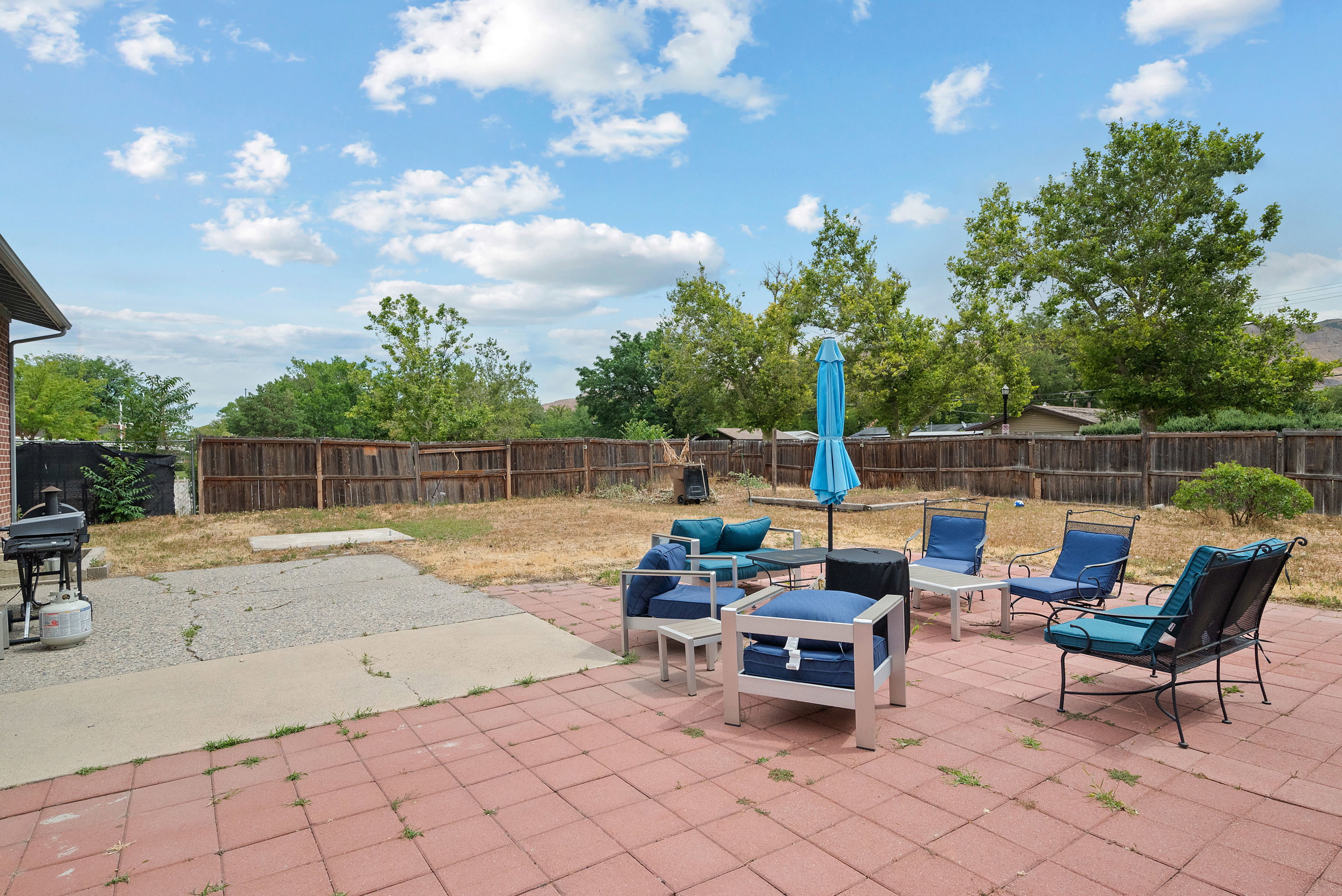 Spacious backyard featuring a brick paver patio, secondary concrete patio, and wood privacy fencing