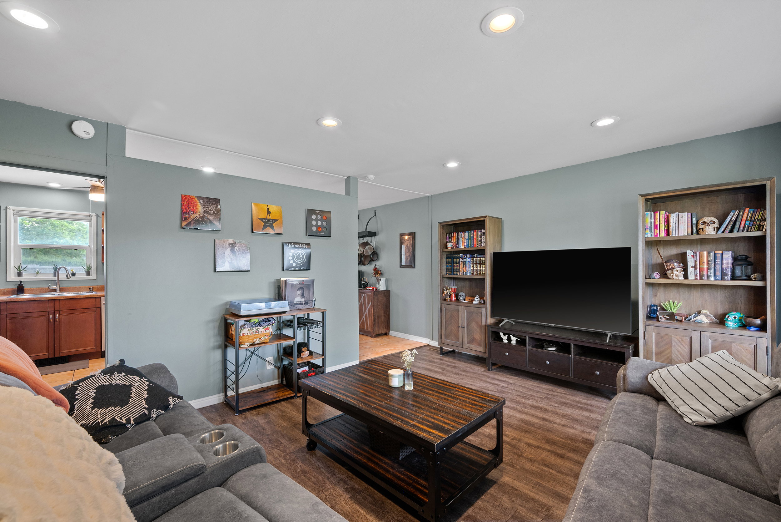 Living area featuring recessed lighting, wood-finish flooring, and built-in shelving units