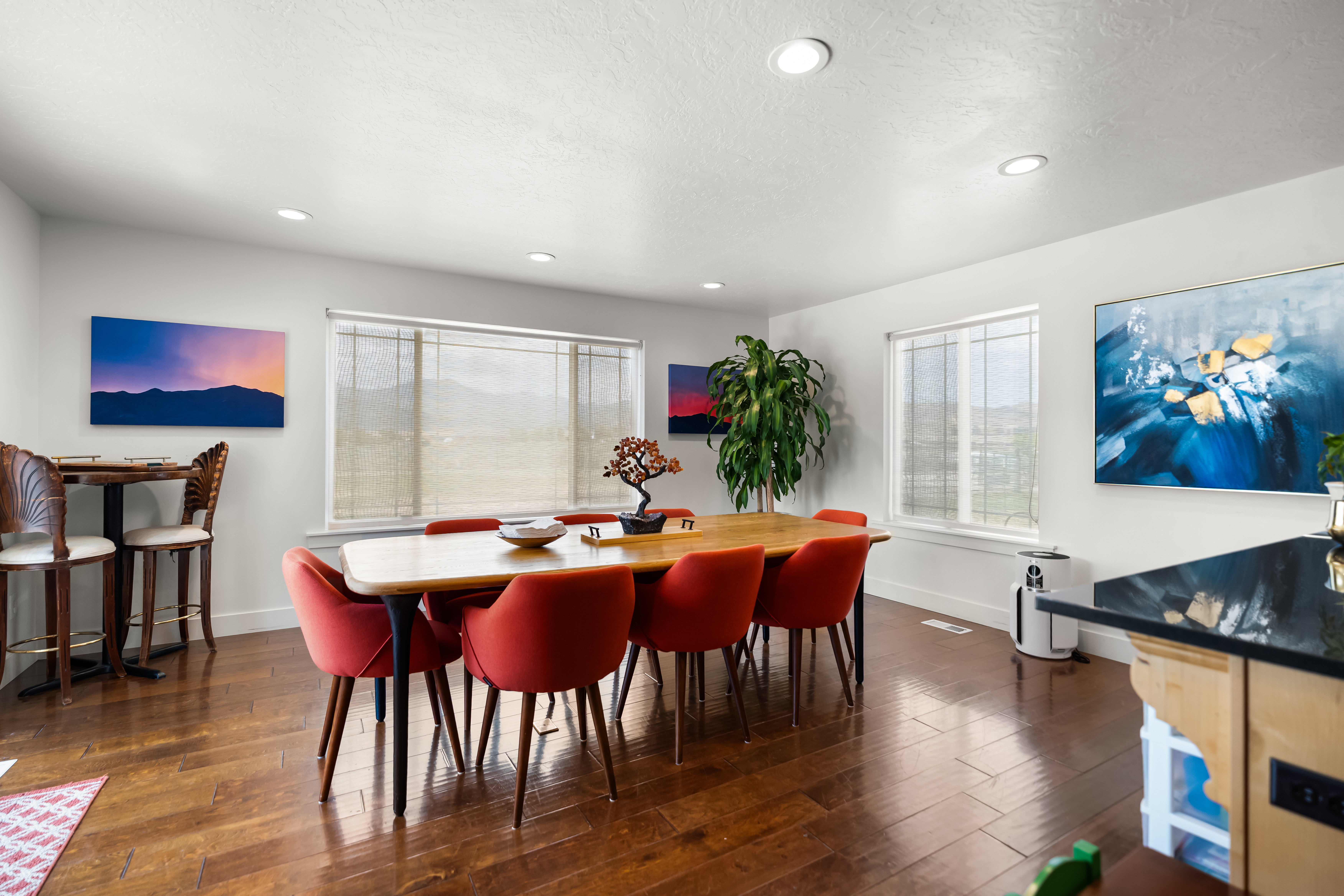 Spacious dining area featuring wood-finish flooring, recessed lighting, and multiple windows