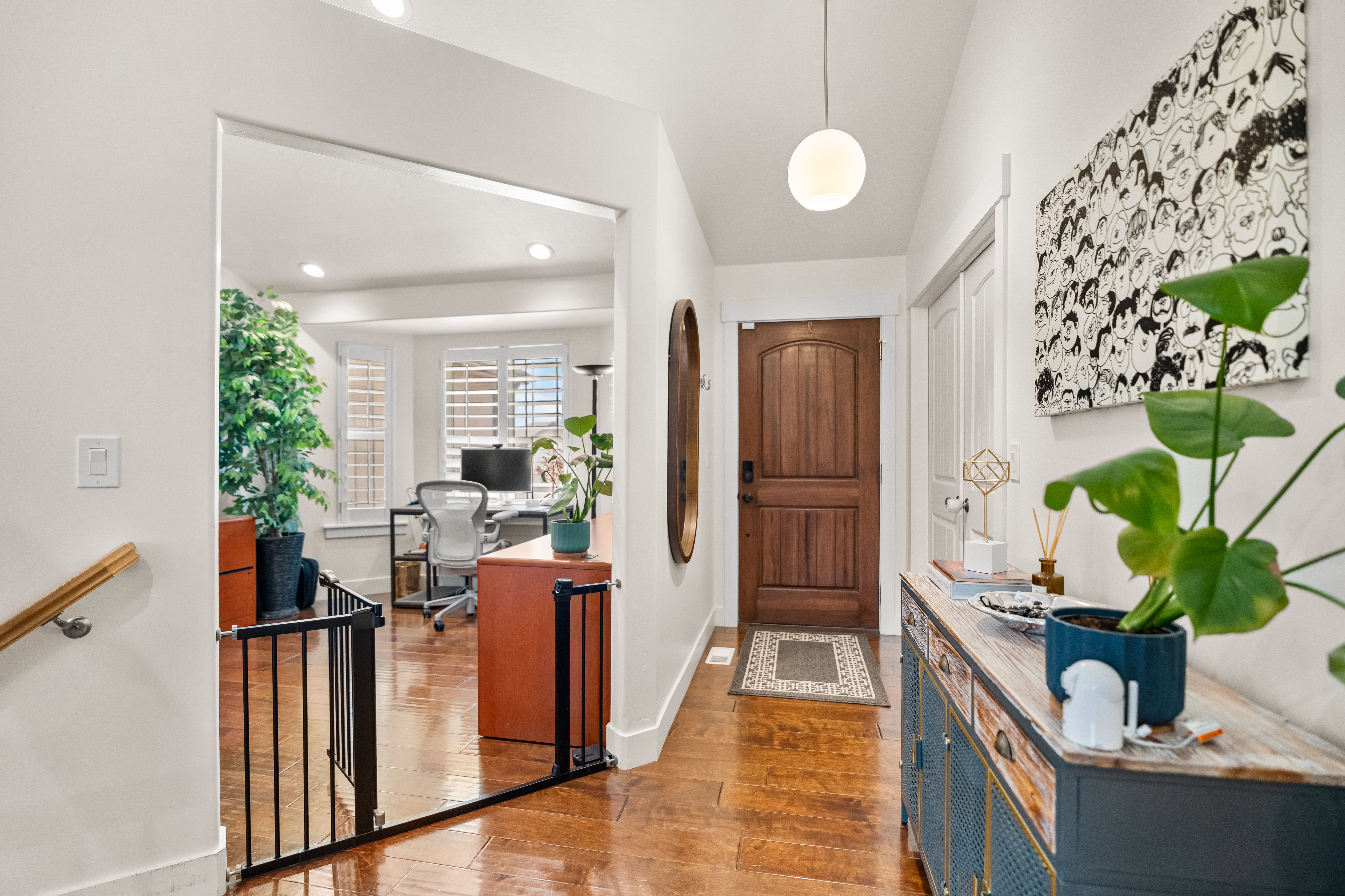 Entryway featuring wood-finish flooring, a solid wood entry door, and a modern spherical pendant light