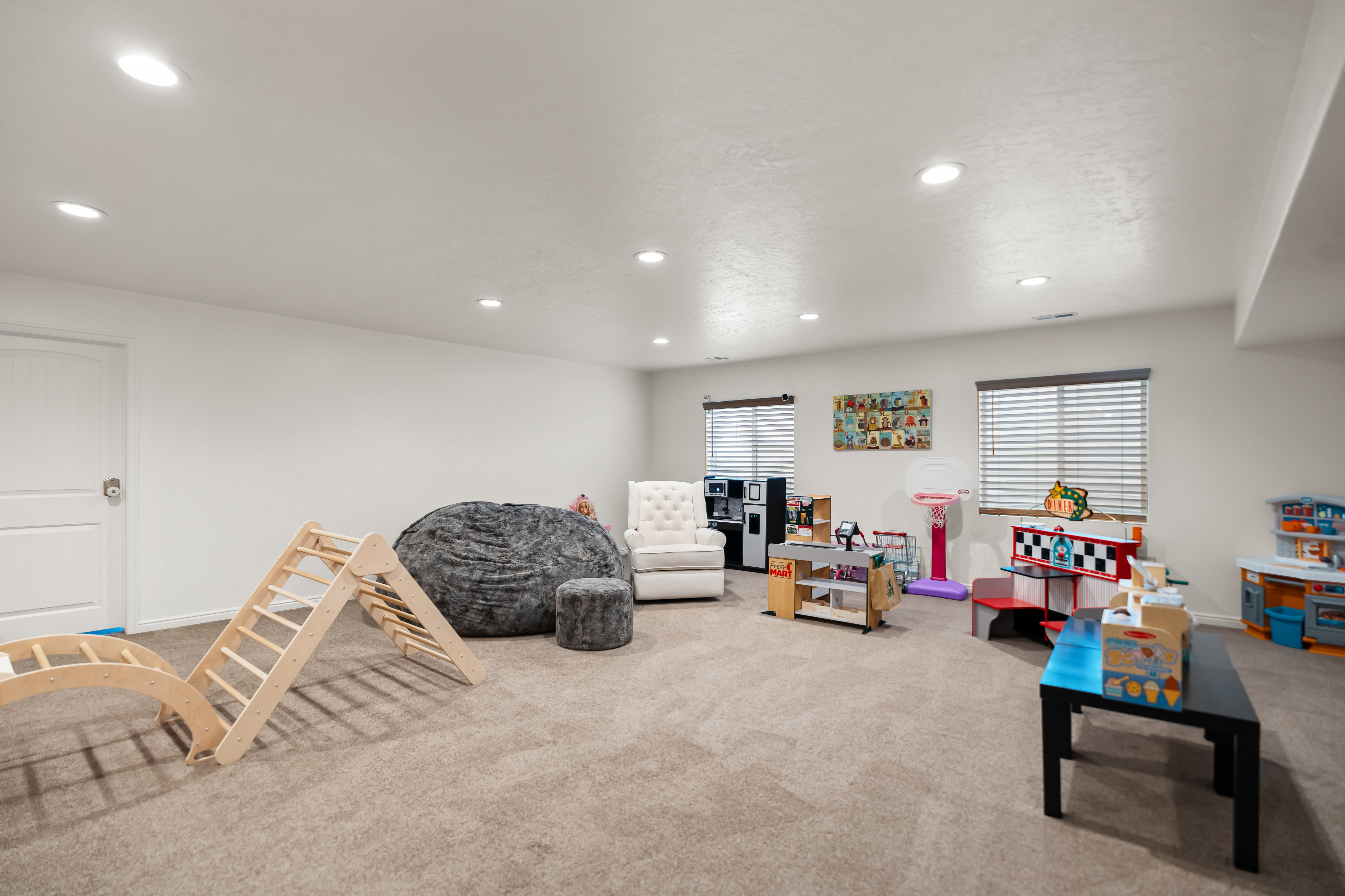 Spacious room featuring neutral carpet flooring, recessed lighting, and white walls
