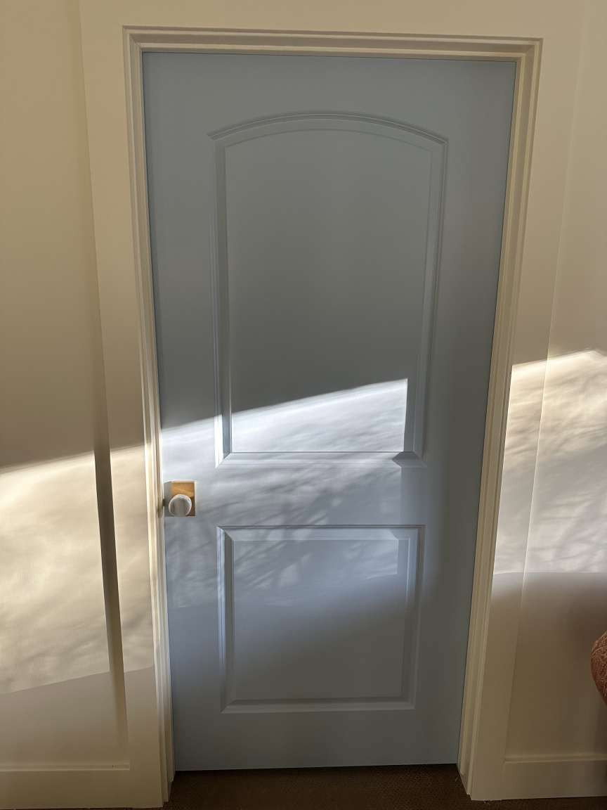 Panel door with arch detail and brass hardware