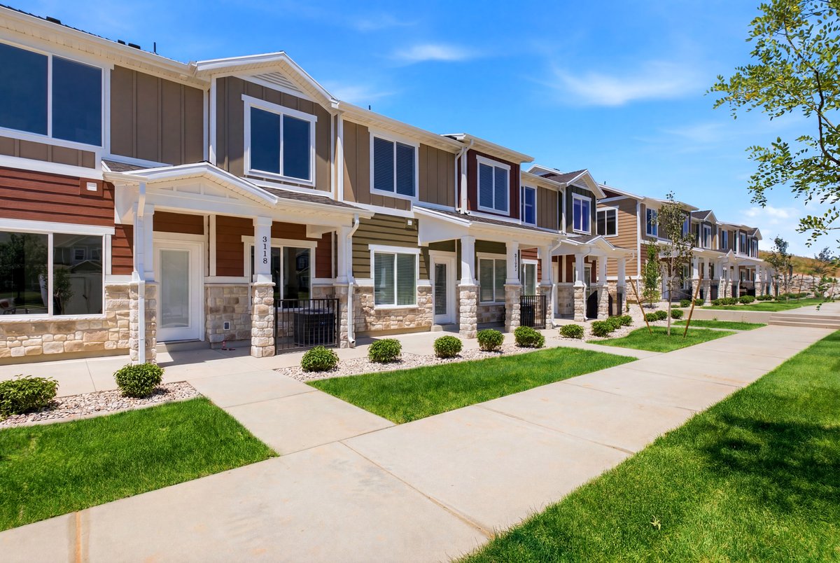 Row of multi-story townhomes featuring stone veneer and varied siding finishes
