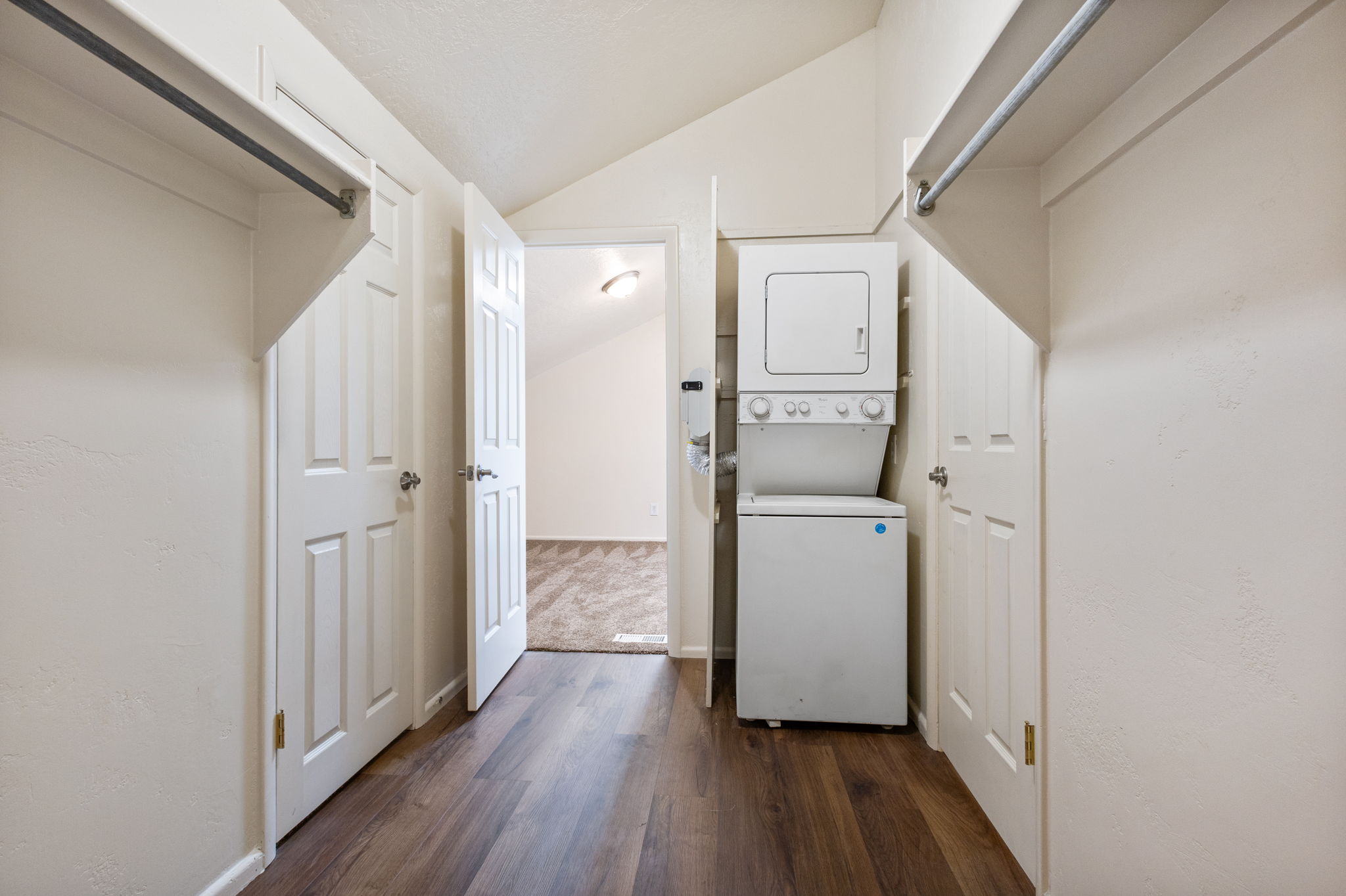 Dedicated laundry area featuring a stacked washer and dryer unit