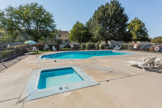 Swimming pool and spa surrounded by a concrete deck