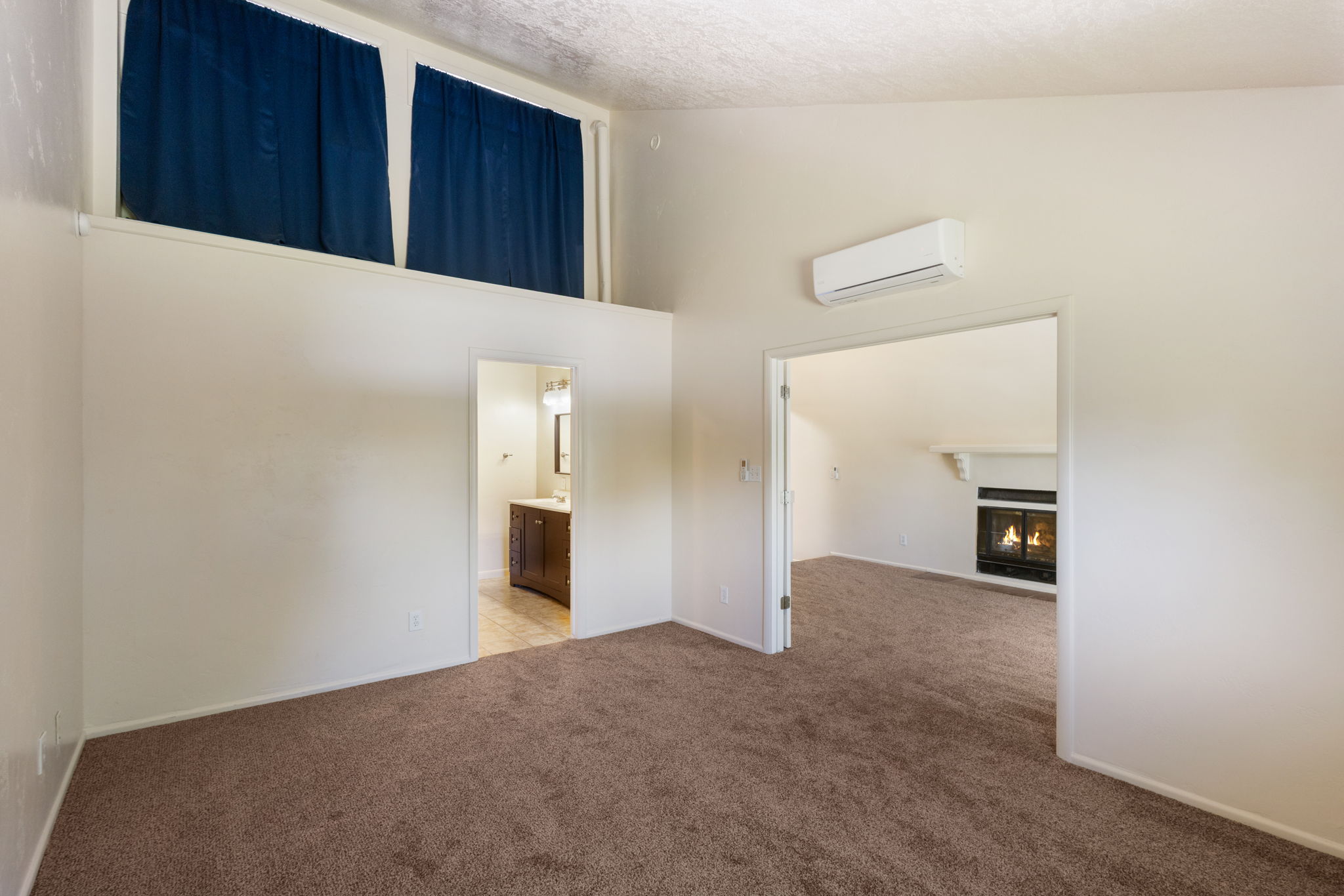 Carpeted interior space with white walls and a high ceiling