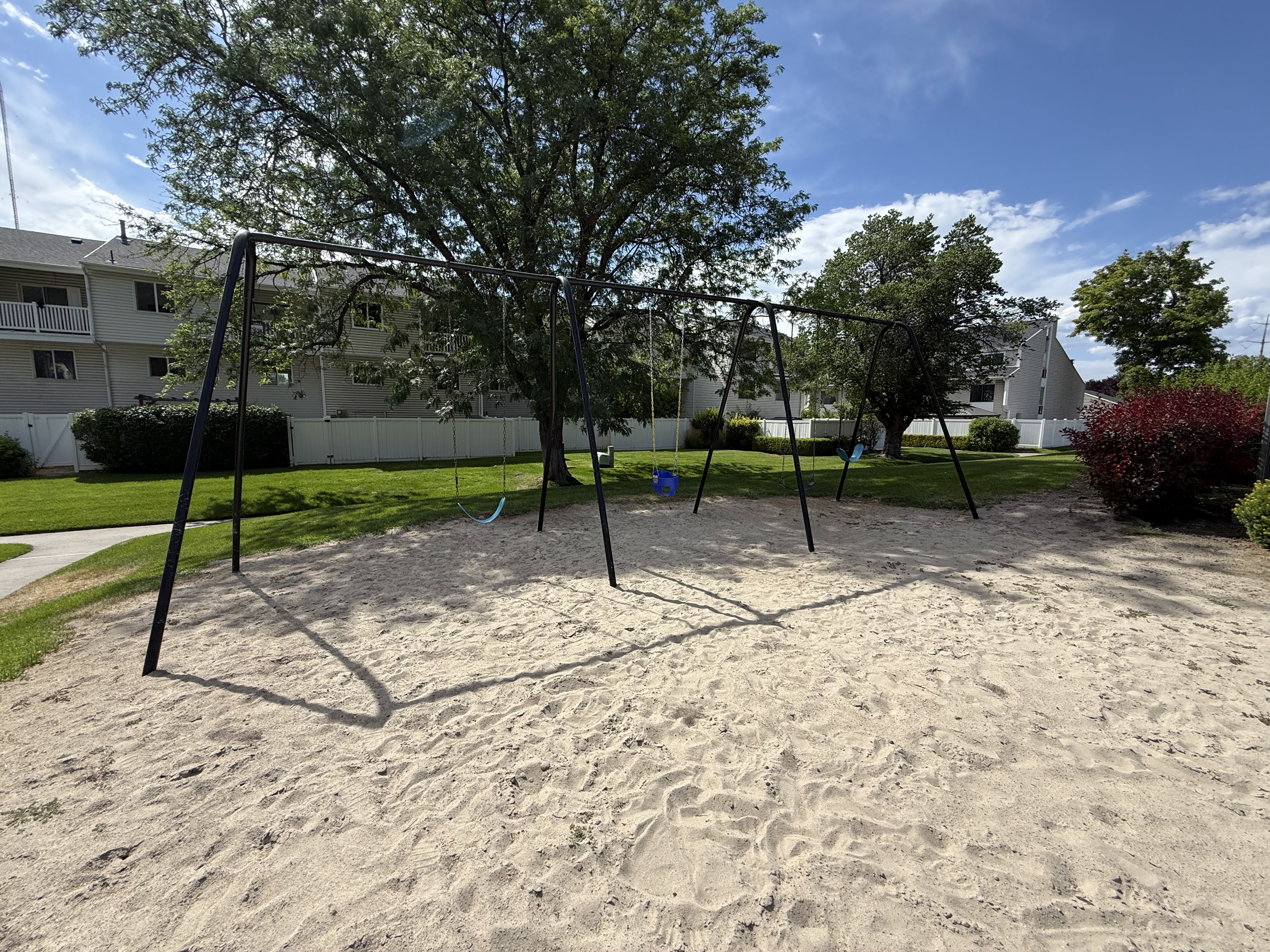 Recreational area featuring a swing set over a sand surface