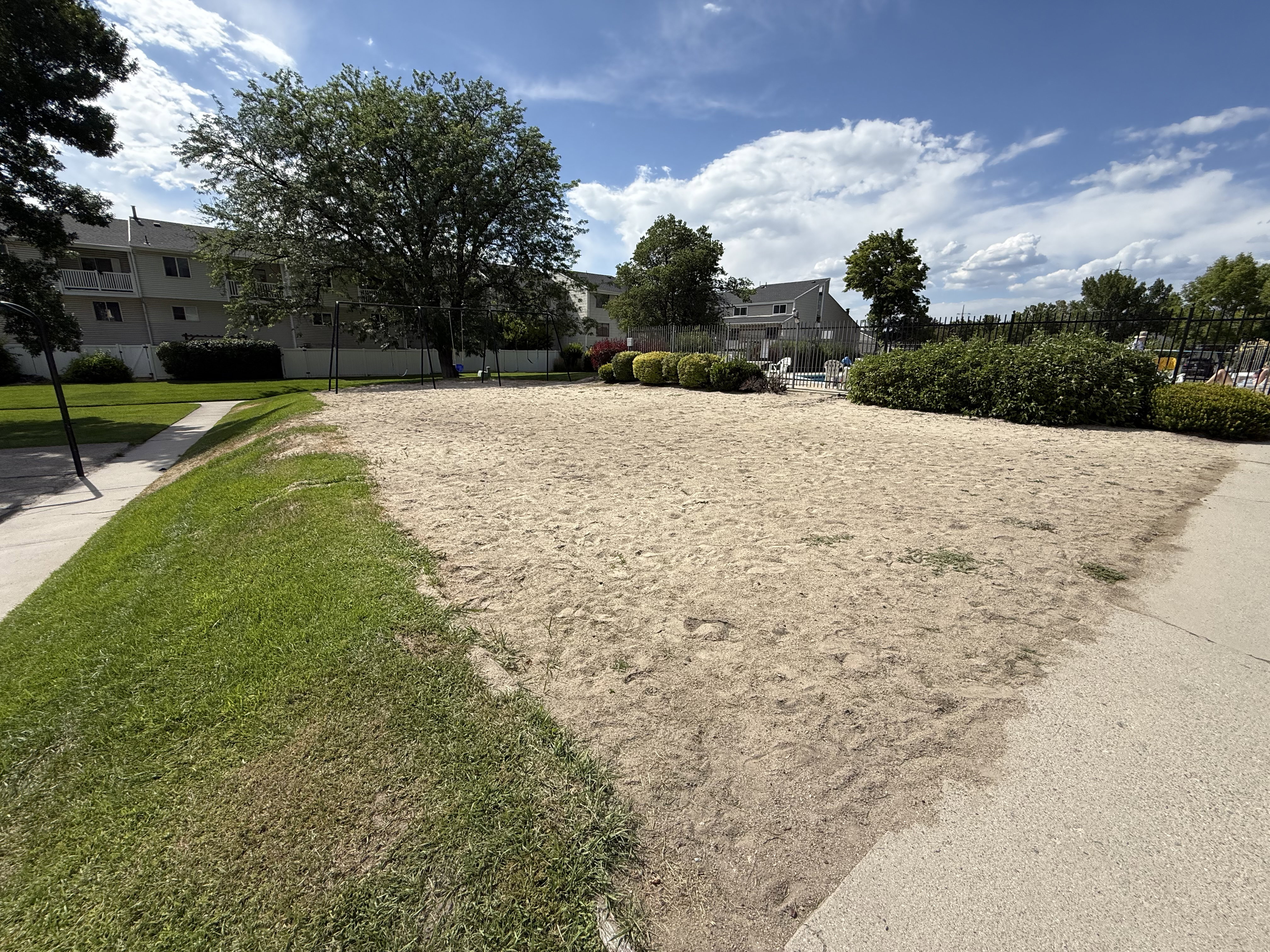 Expansive sand recreation area with bordering concrete pathways