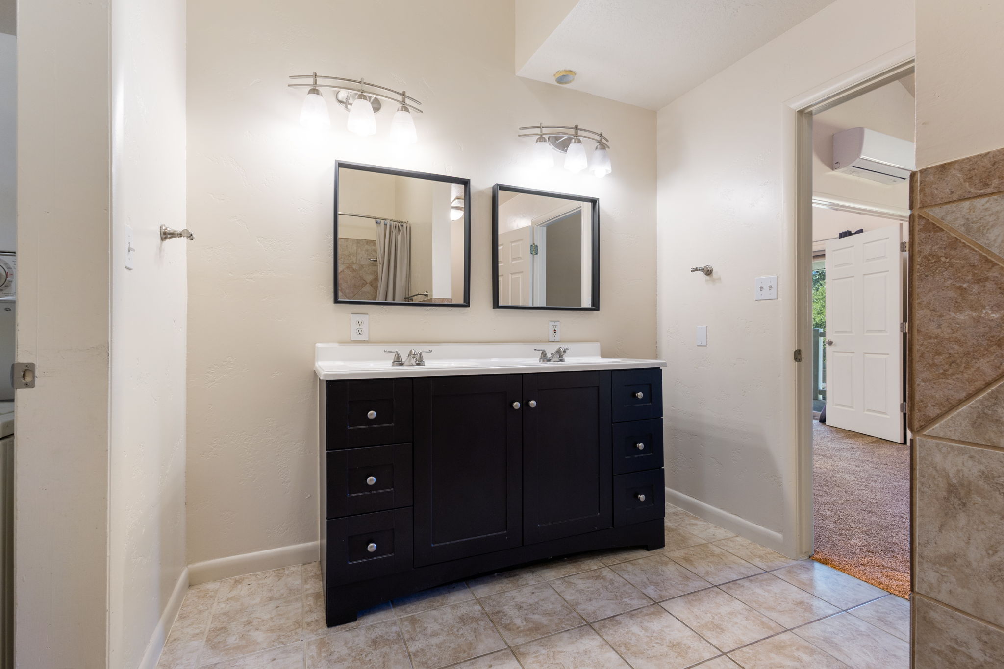 Dual vanity with dark wood-finish cabinetry and white countertops