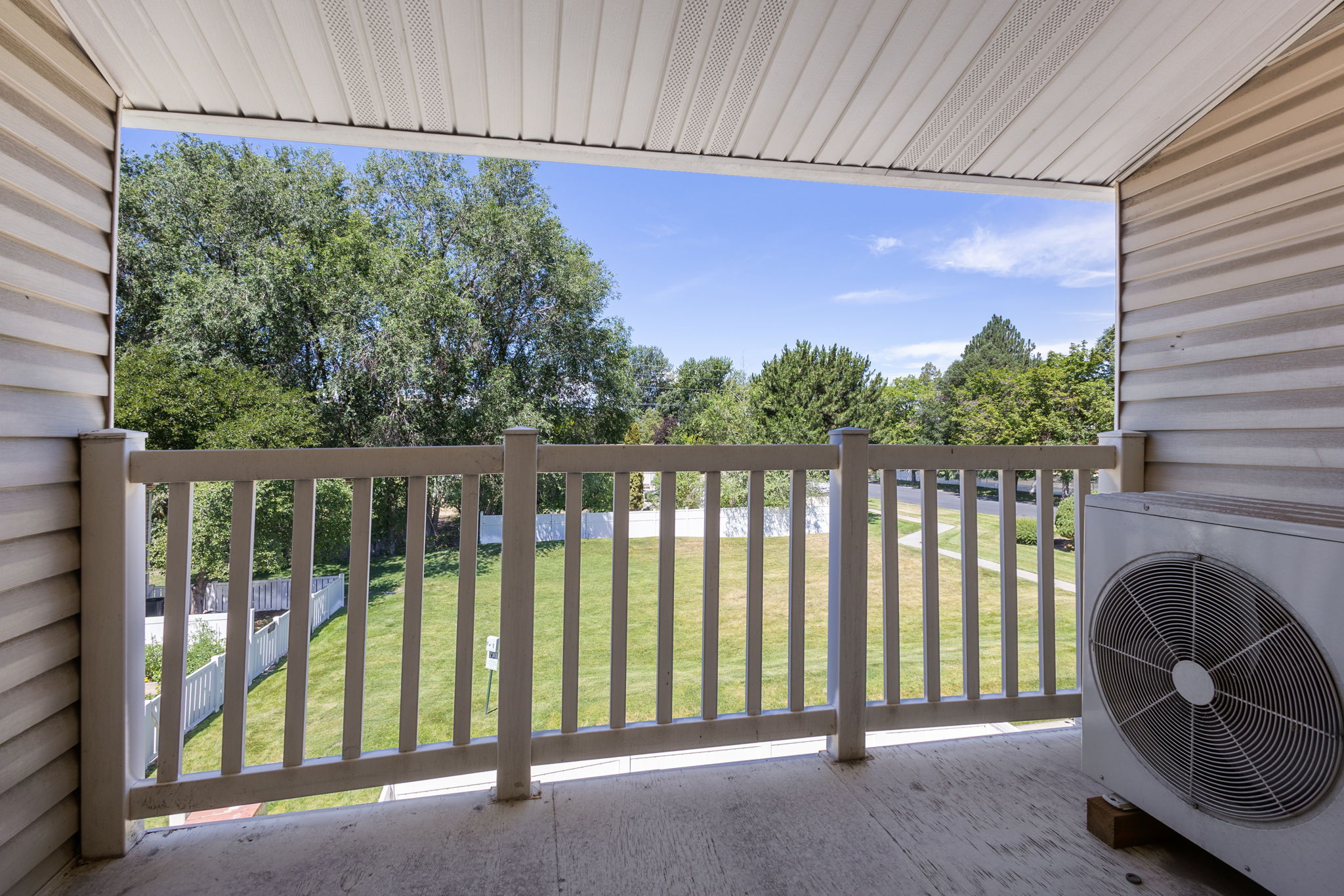 Covered balcony featuring a wood-finish railing and outdoor flooring