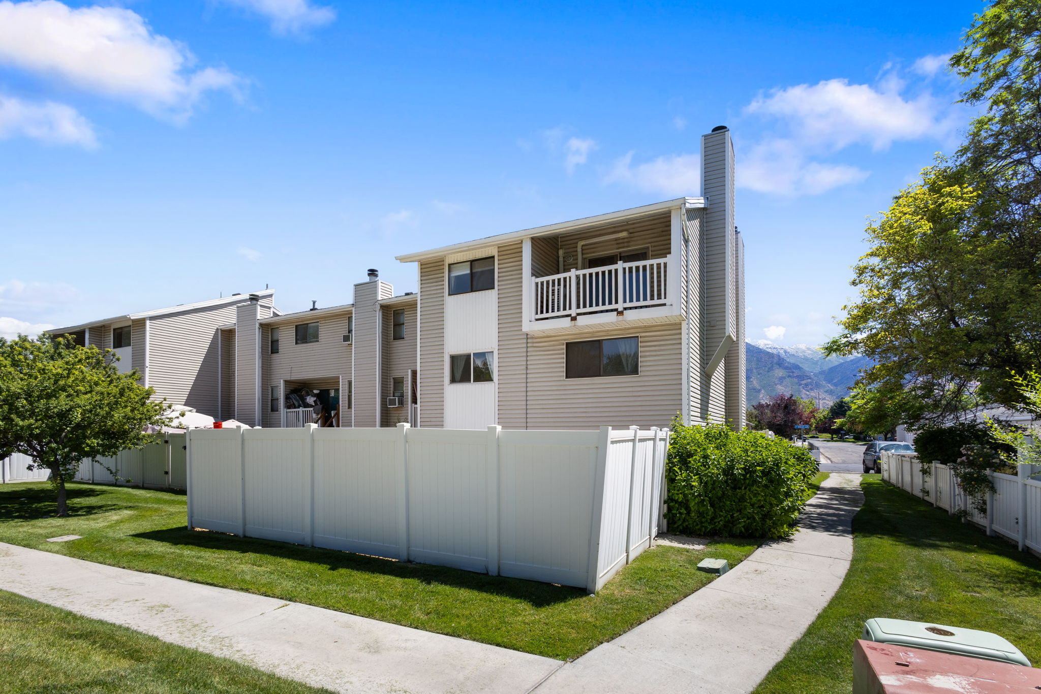 Multi-level residential building featuring light-toned siding and white trim