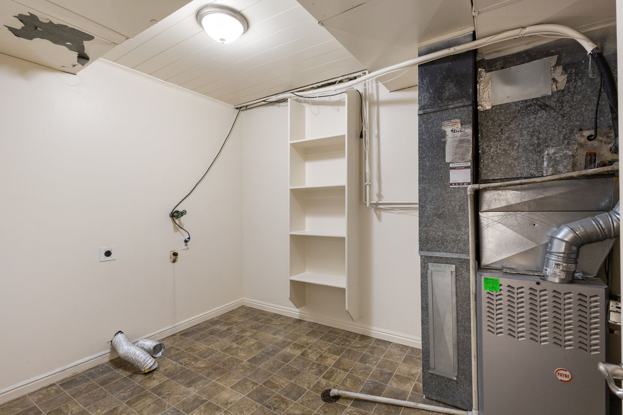 Utility area featuring built-in shelving, vinyl flooring, and a flush-mount ceiling light fixture
