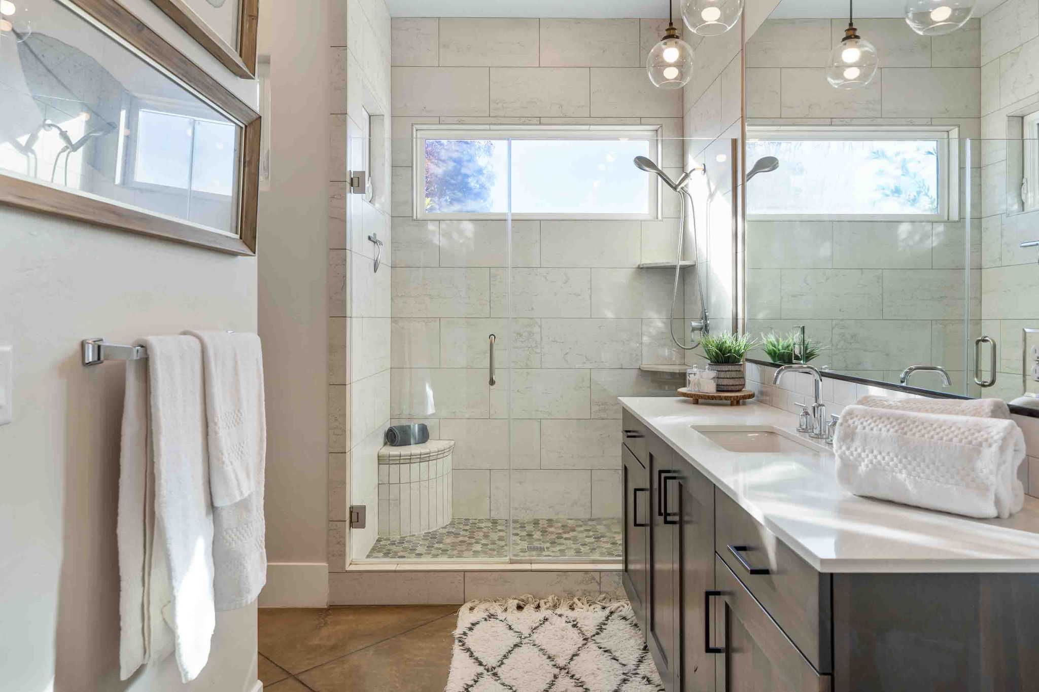 Contemporary bathroom featuring a spacious glass-enclosed shower with pebble-tile flooring and a built-in bench