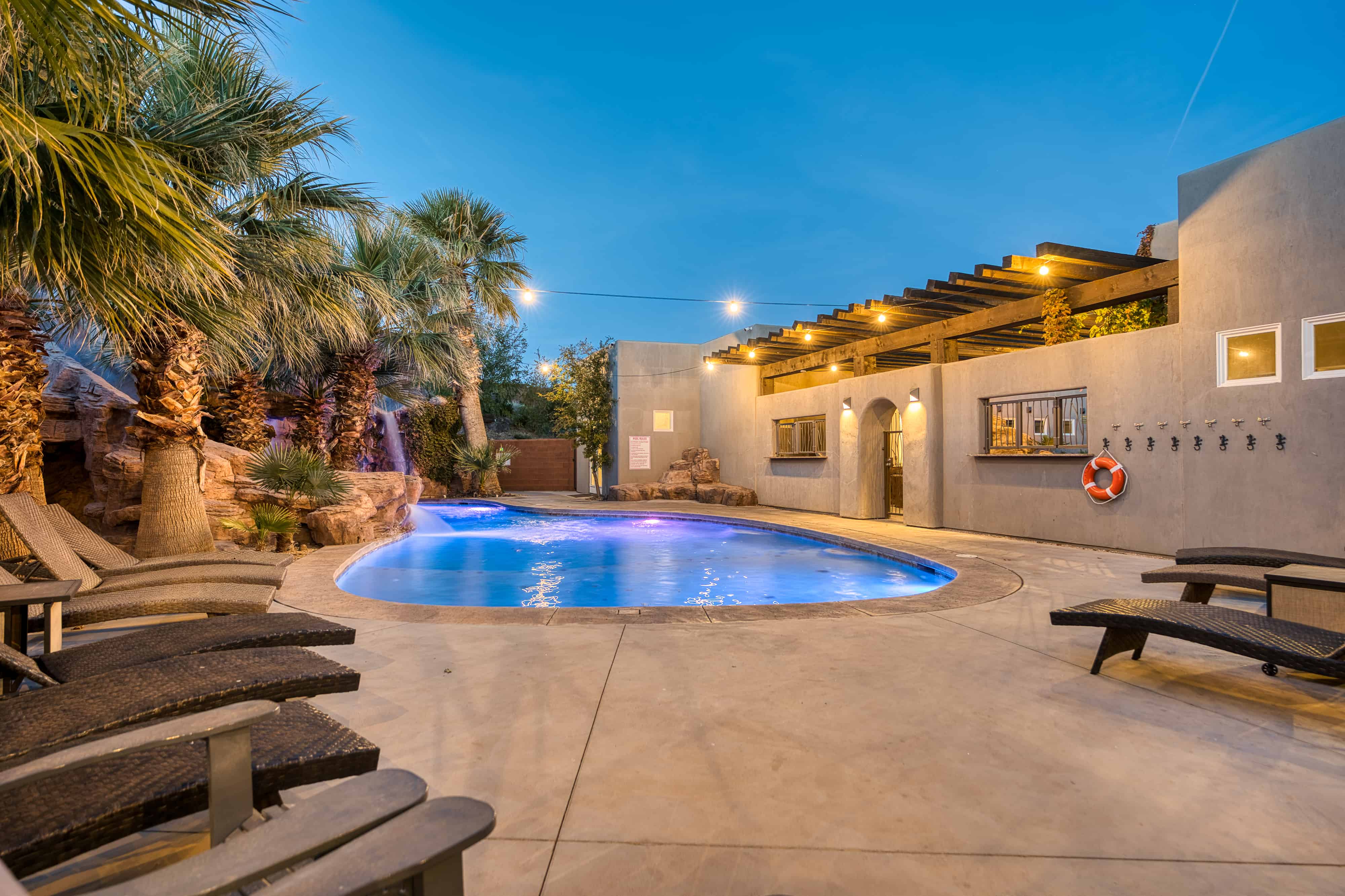Resort-style pool area featuring a freeform swimming pool with integrated waterfall and spa