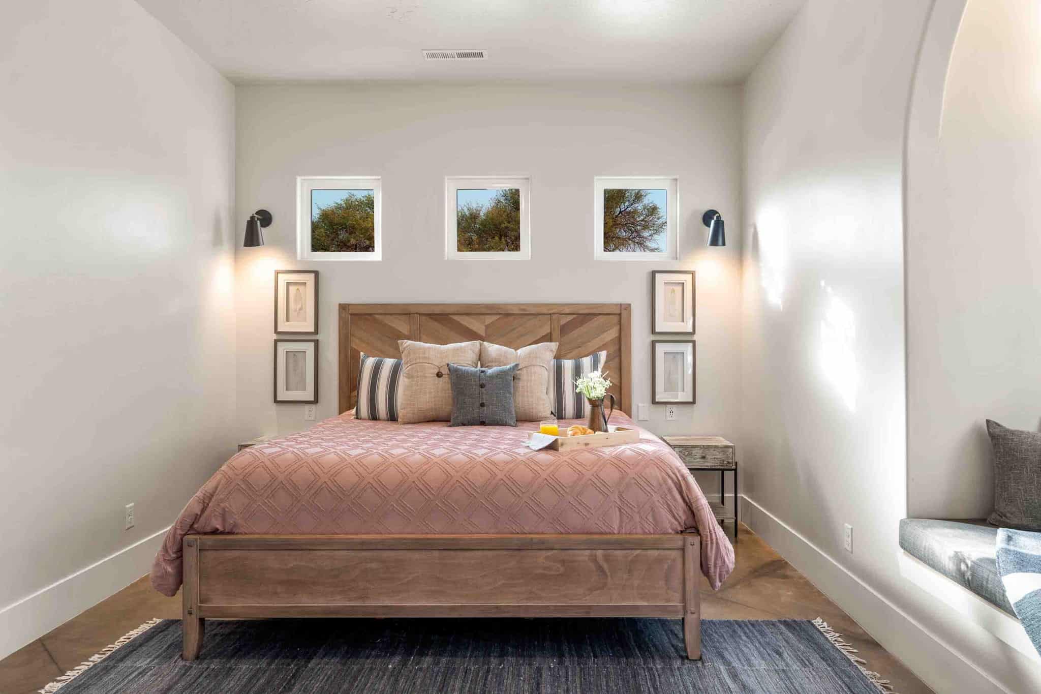 Wood-finish flooring anchors this bedroom featuring a built-in window seat with an arched alcove