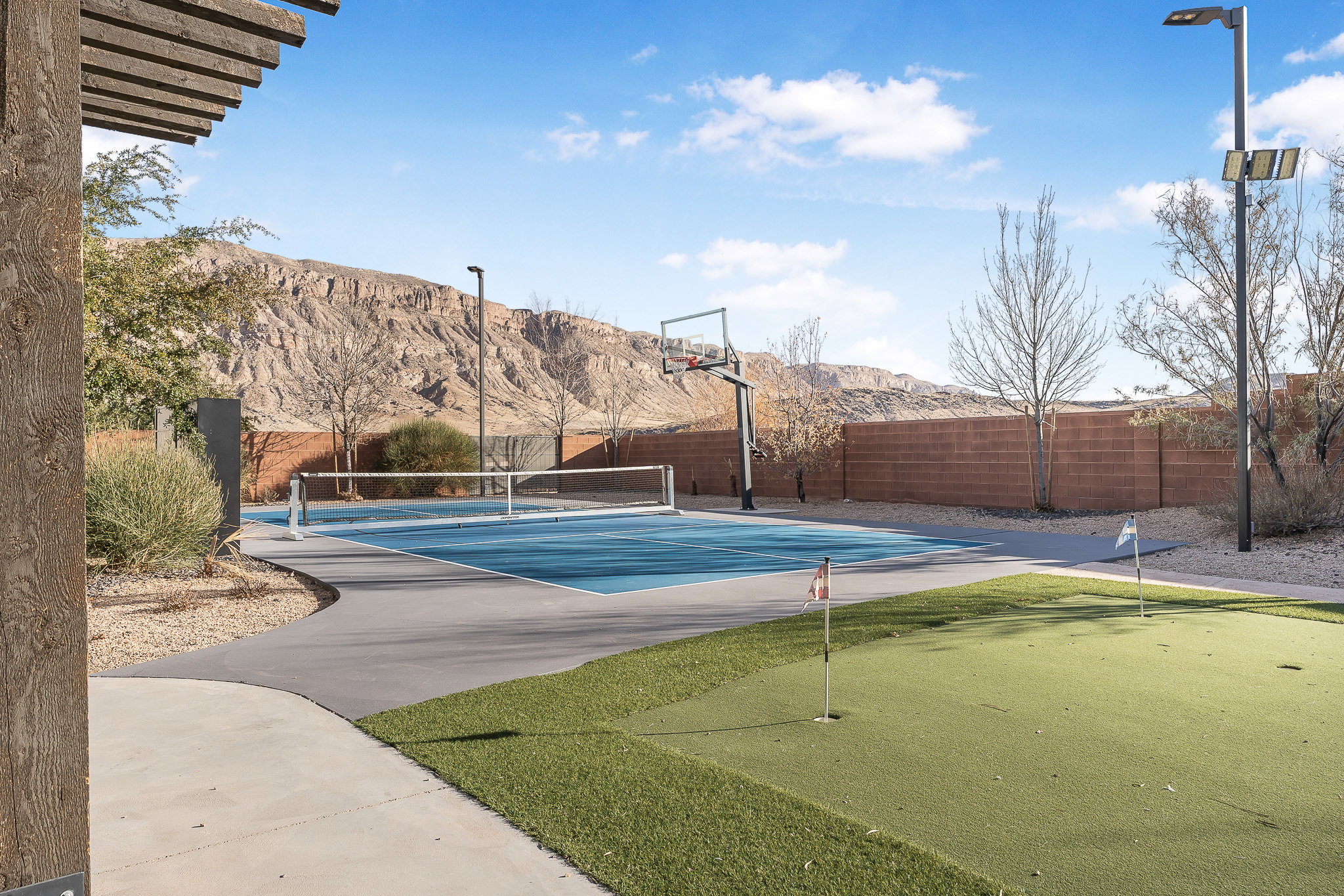 Multi-sport court featuring a basketball hoop and pickleball net