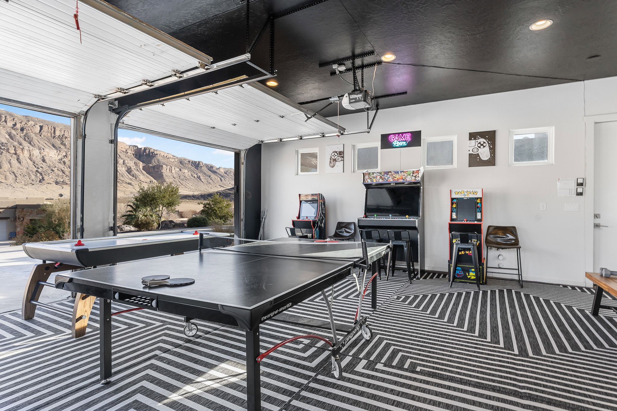 Versatile indoor-outdoor area with an open garage door framing a mountain backdrop