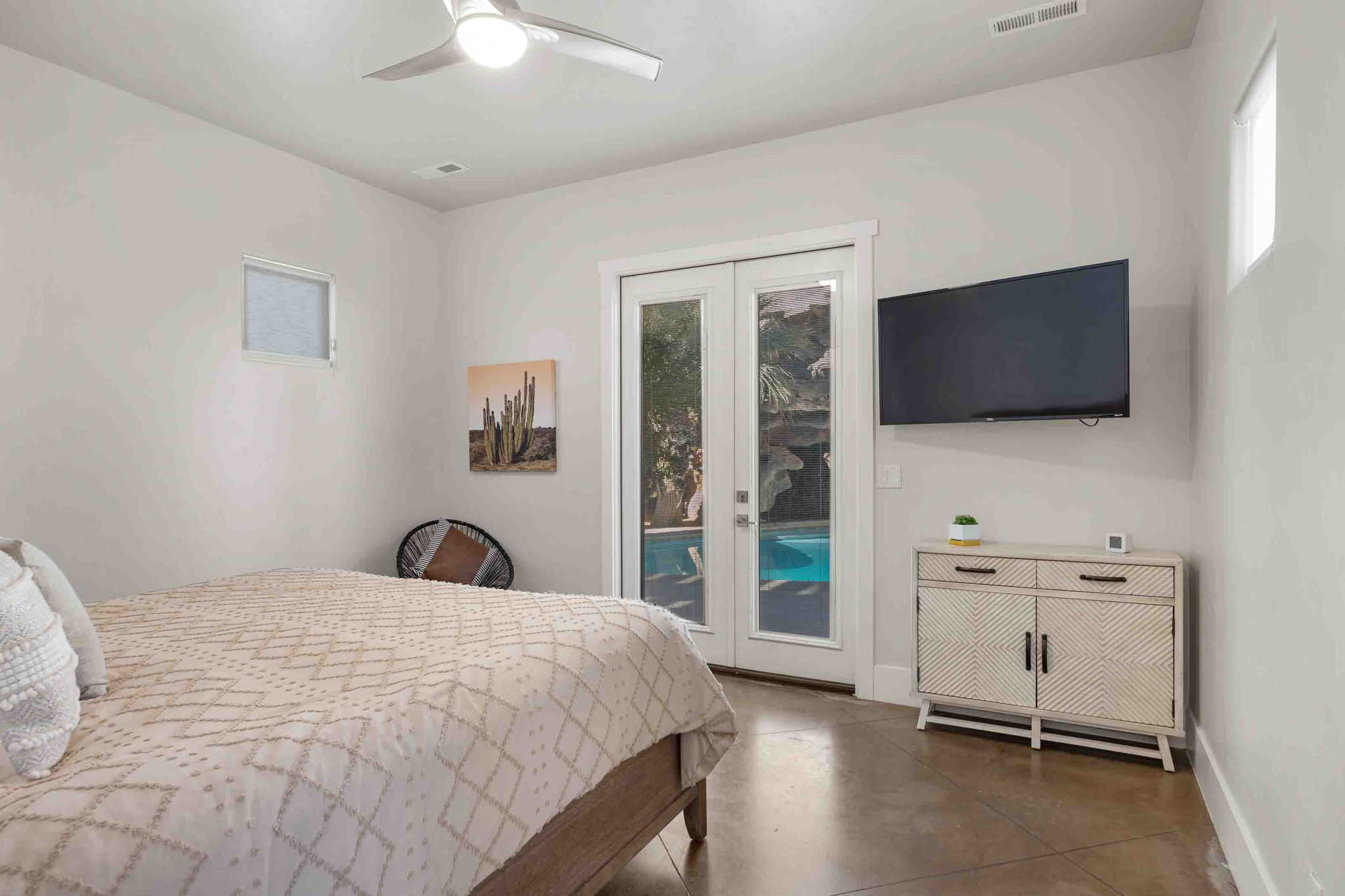 Interior room featuring a ceiling fan, dual French doors with exterior pool access, and polished concrete flooring