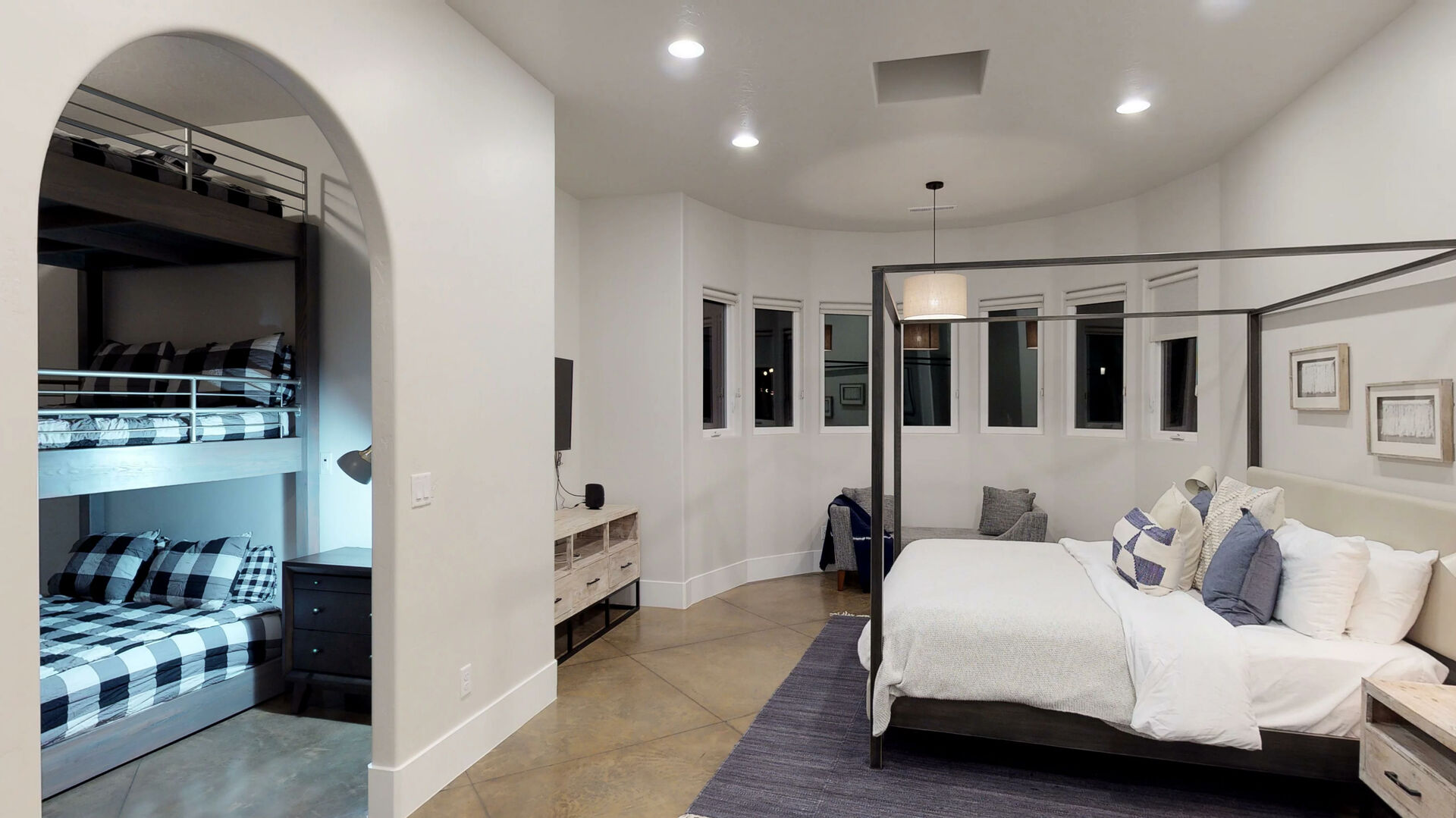 Recessed lighting illuminates this room featuring a curved wall with multiple windows and a built-in bunk bed alcove