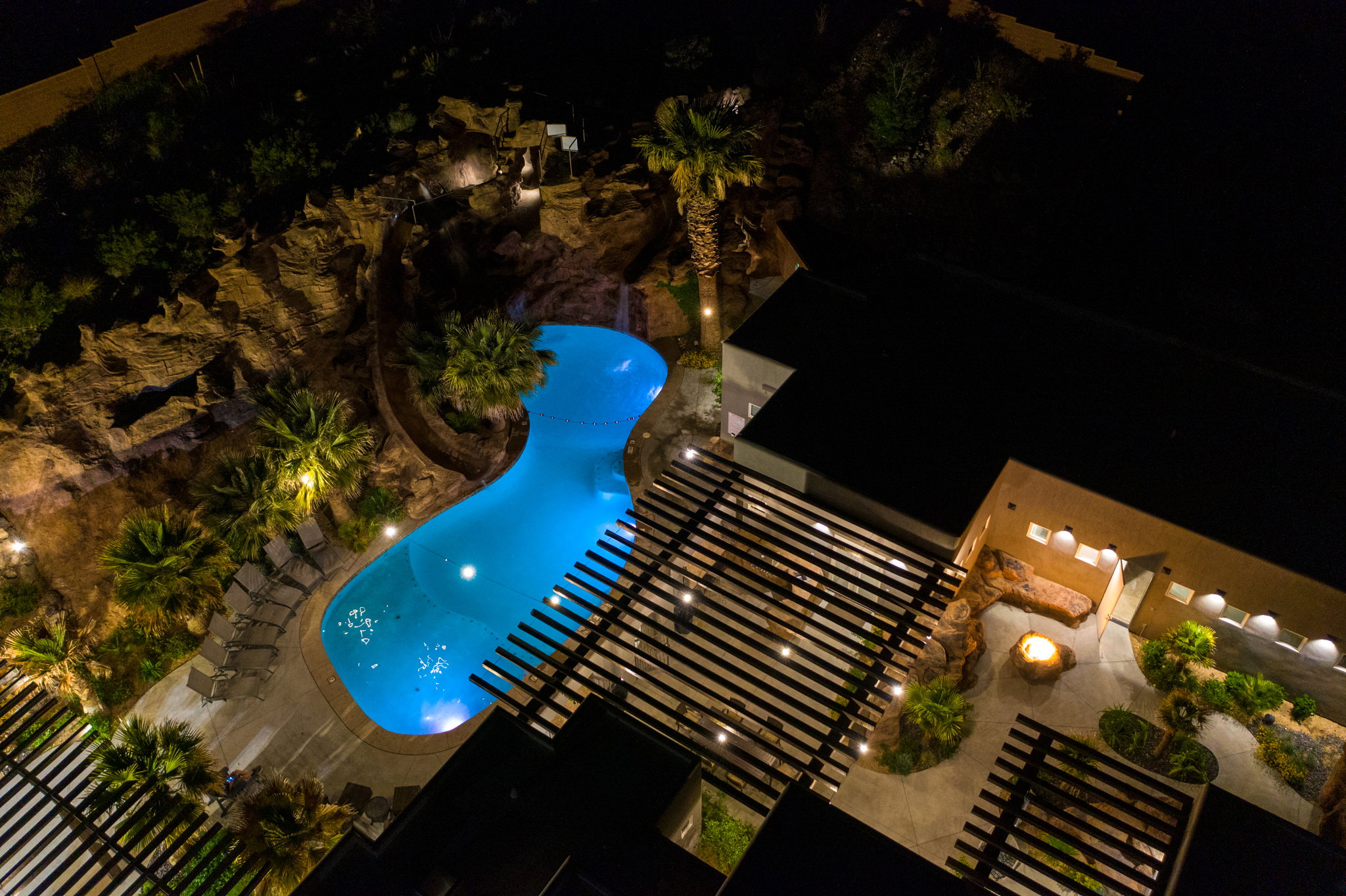 Freeform pool with a rockscape, lush landscaping, and integrated water feature