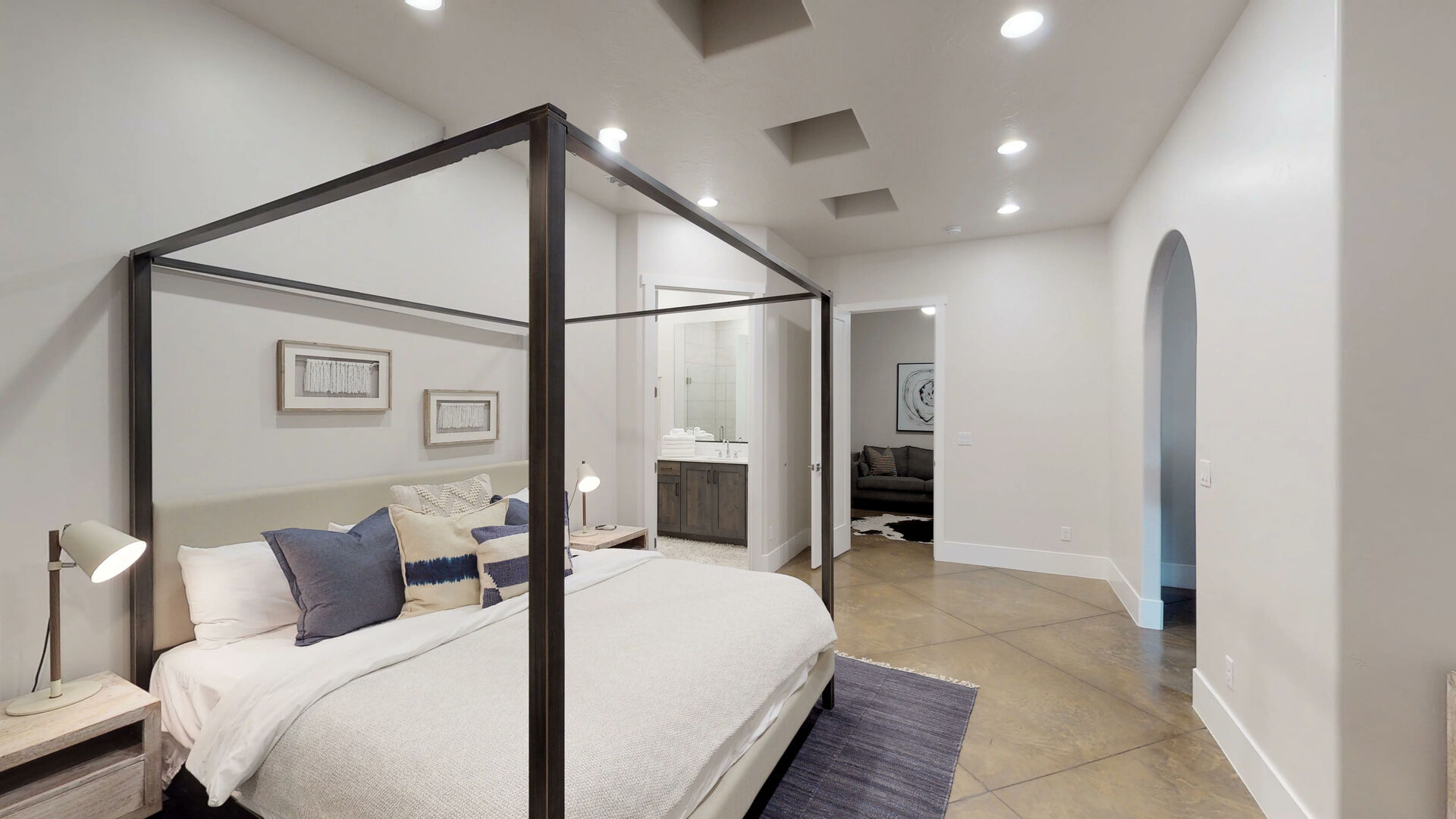 Spacious bedroom featuring high vaulted ceilings, recessed lighting, and polished concrete flooring
