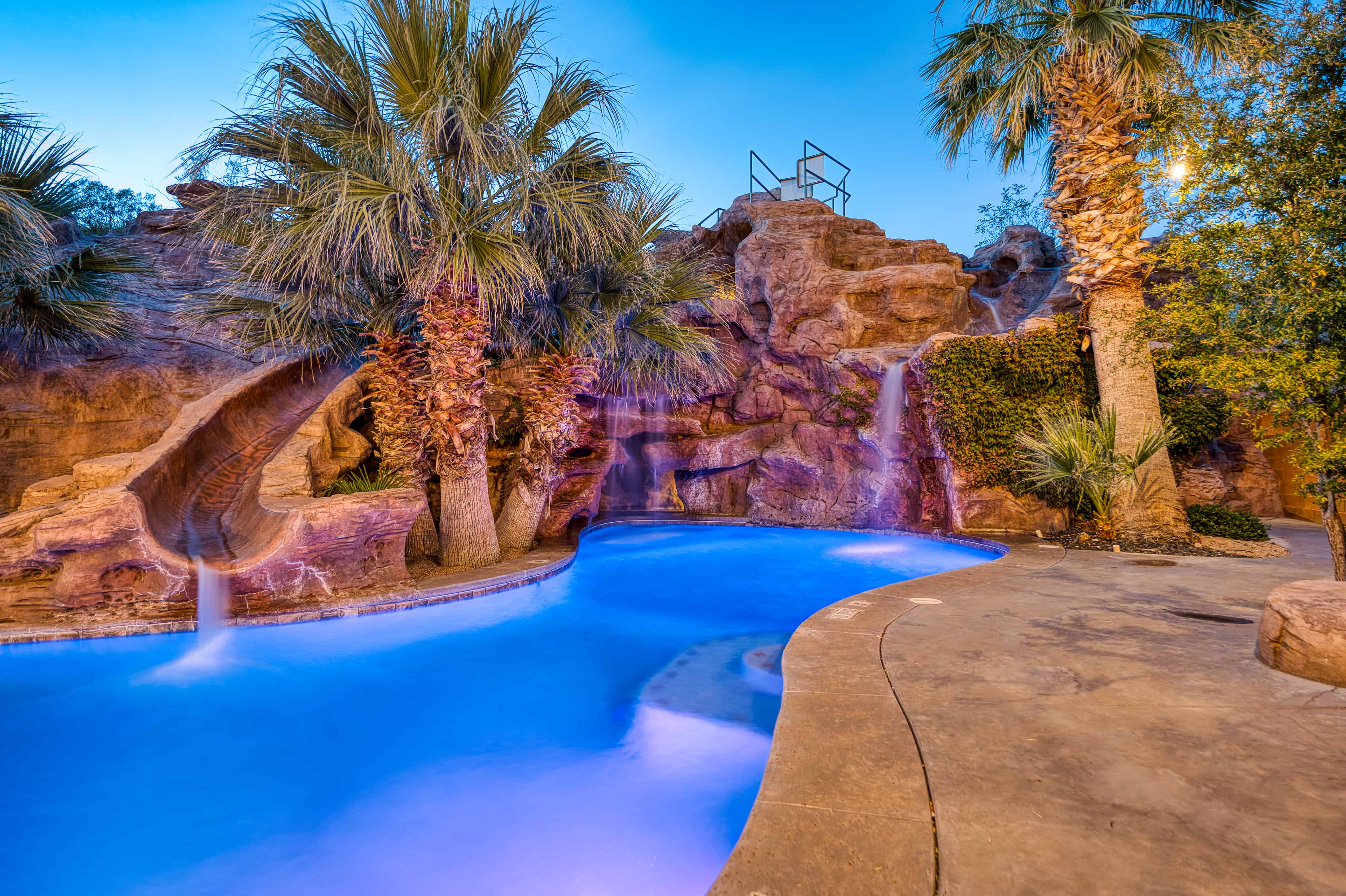 Custom pool featuring a rock grotto with a waterfall and integrated slide
