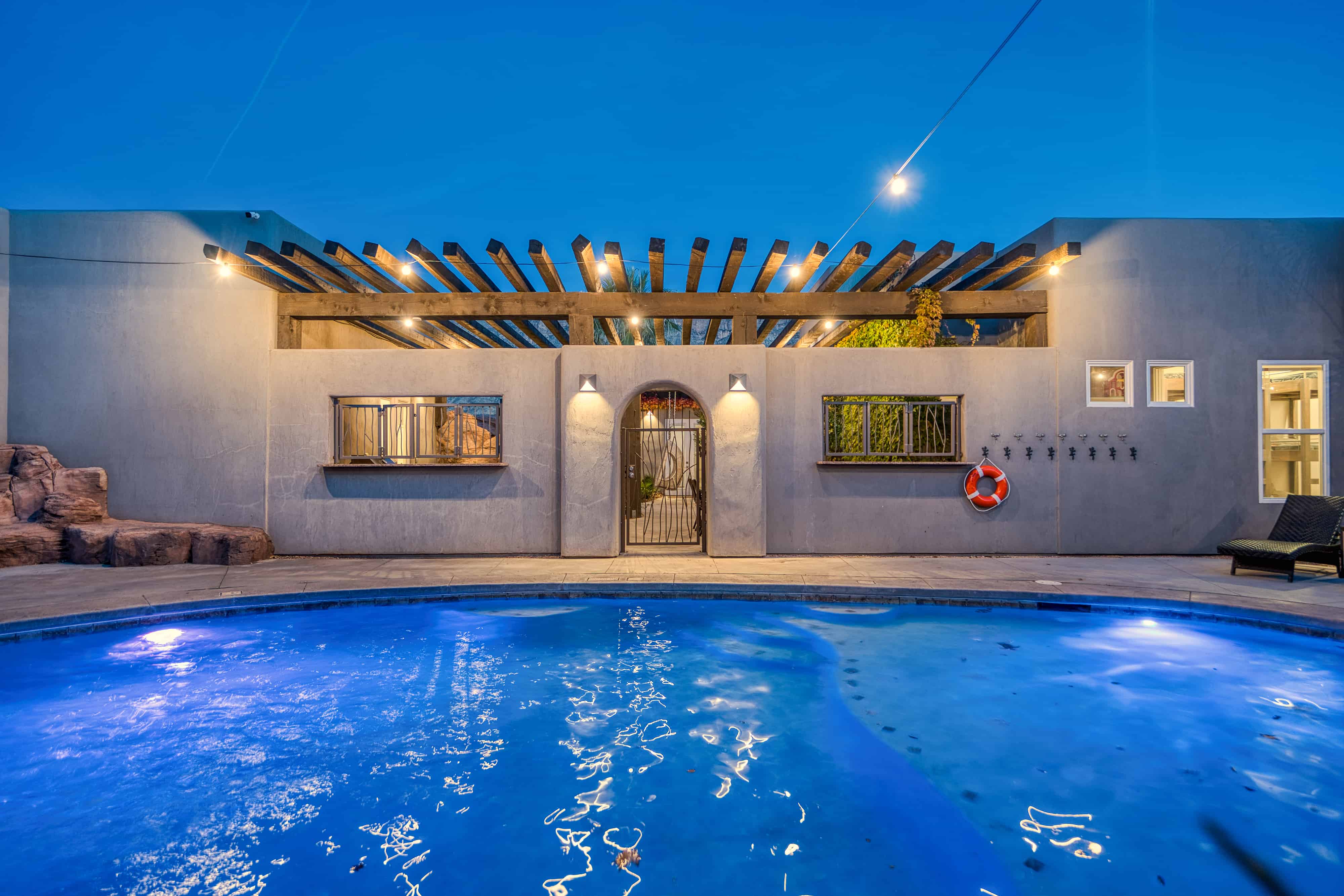 Outdoor swimming pool with built-in rock features and integrated lighting