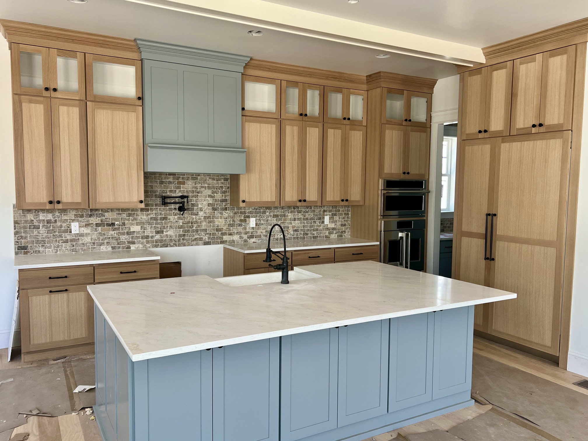 Spacious kitchen featuring a large central island with a white countertop and blue cabinetry