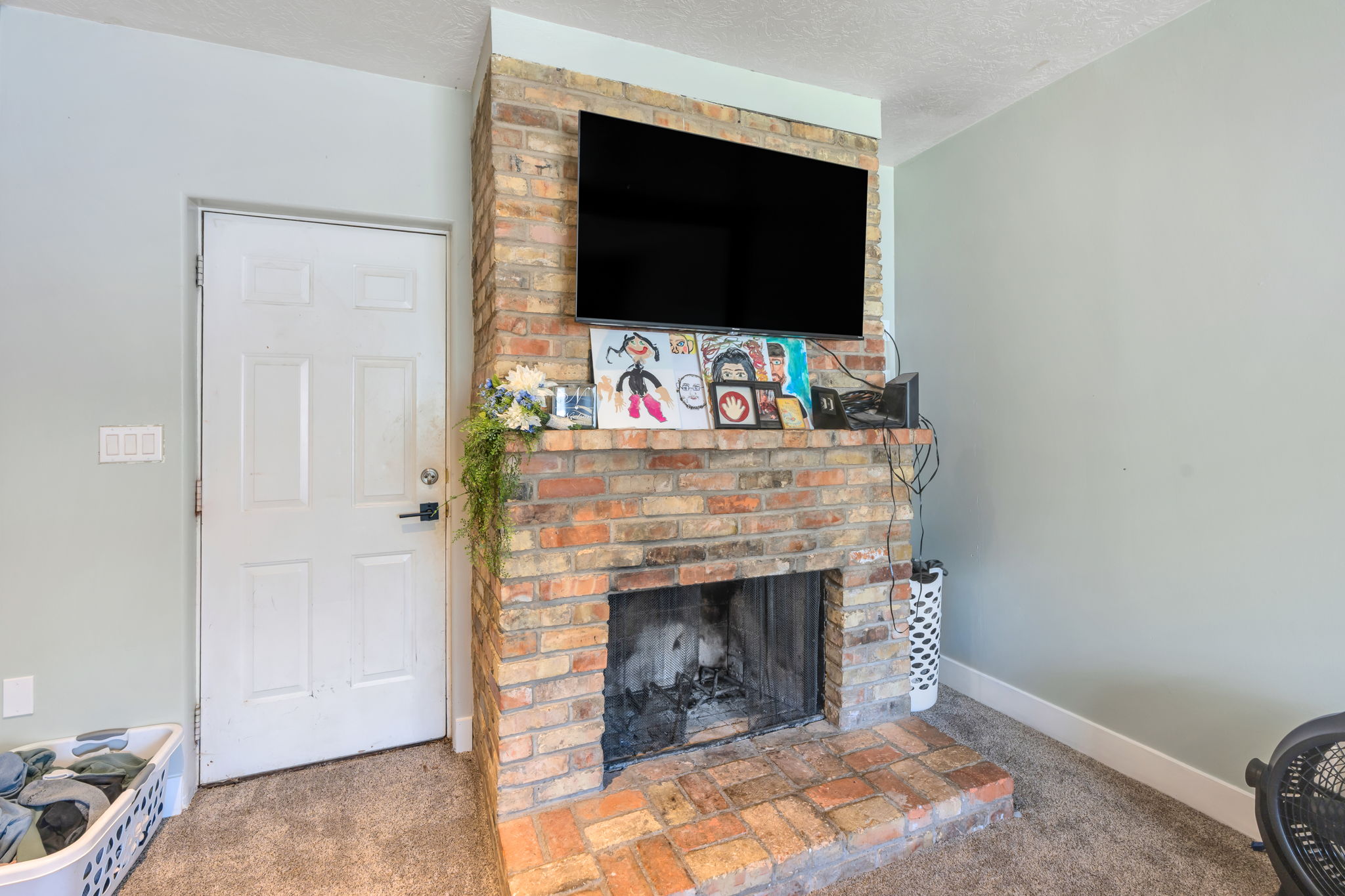 Brick fireplace with an integrated hearth, featuring a dark metal firebox
