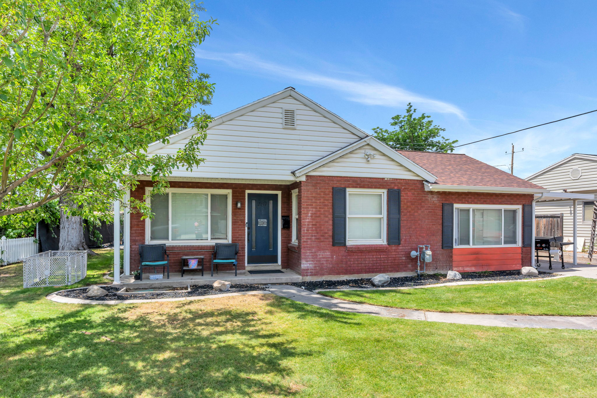 Brick exterior with white siding accents and a covered front porch