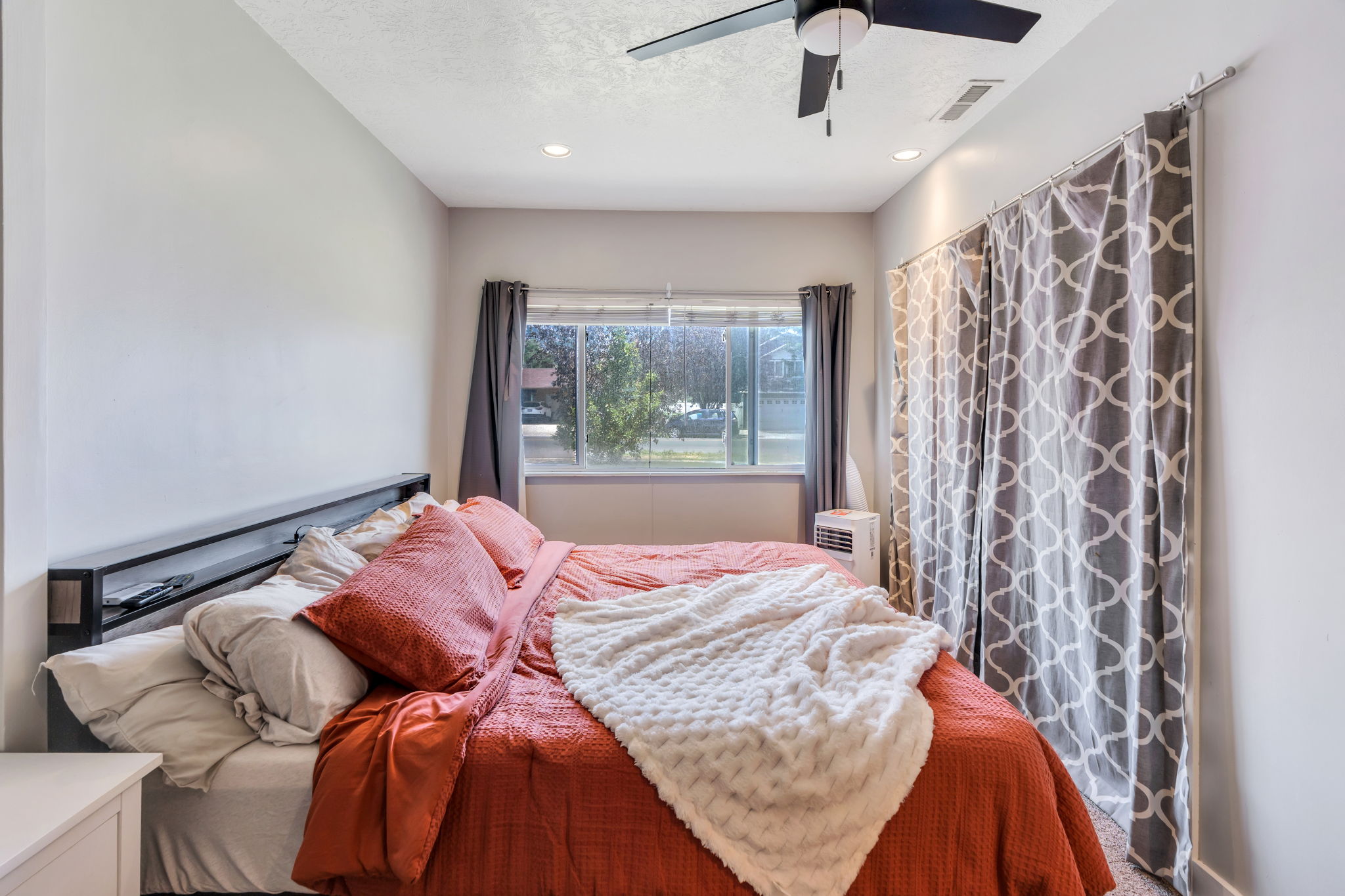 White walls and a built-in headboard create a streamlined aesthetic