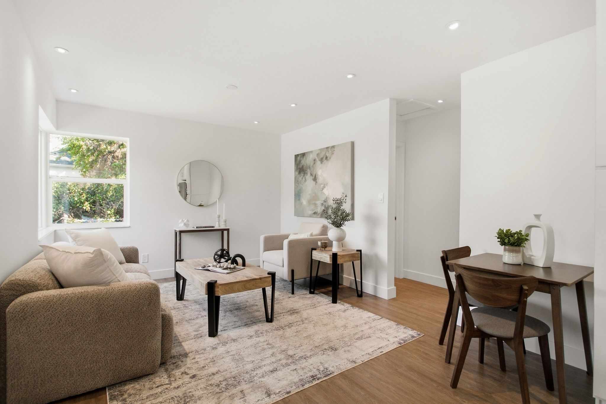 Open-concept living area featuring wood-finish flooring, recessed lighting, and a neutral color palette