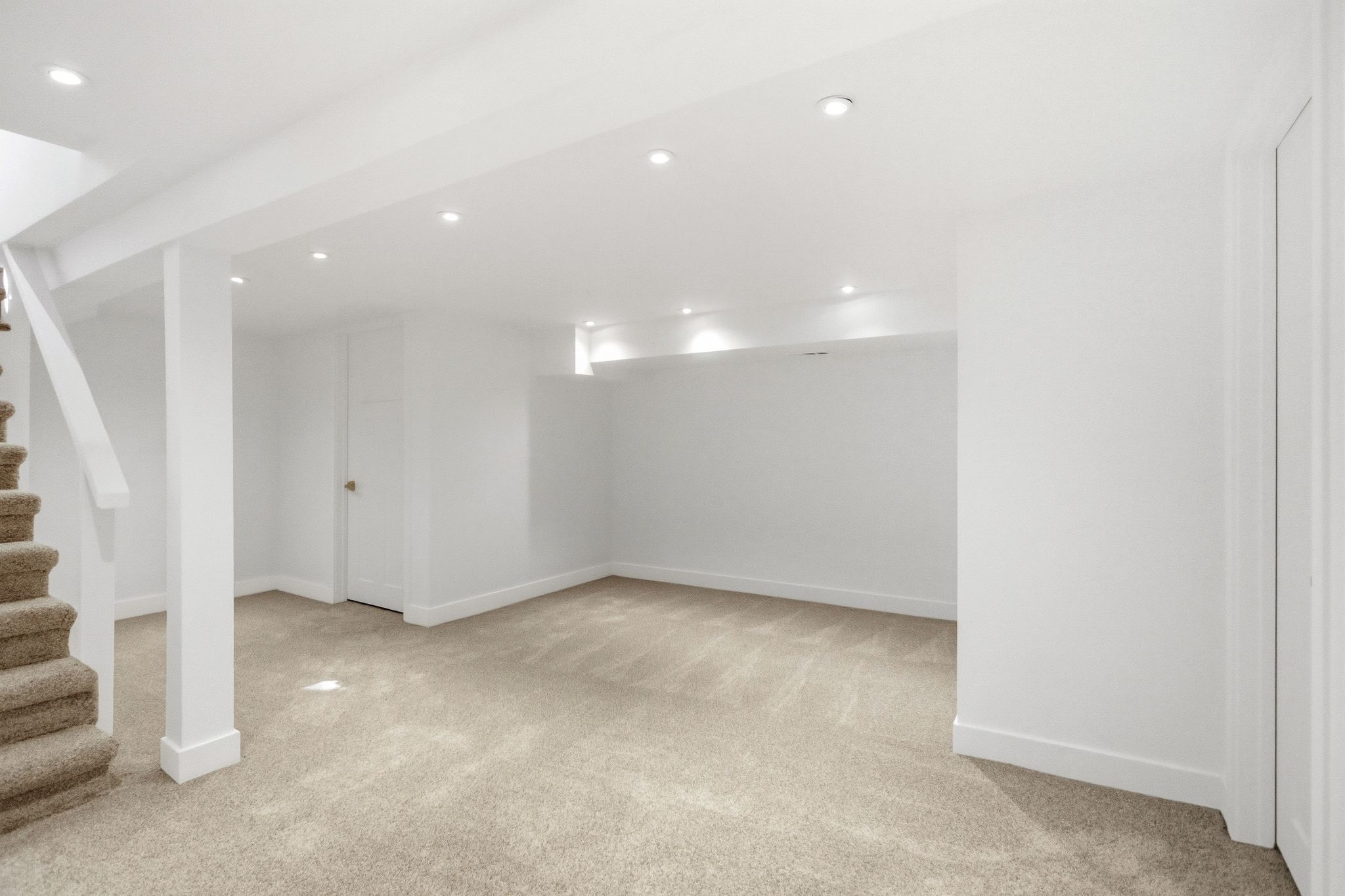 Spacious lower level featuring light-toned carpet flooring, recessed lighting, white walls, and white trim