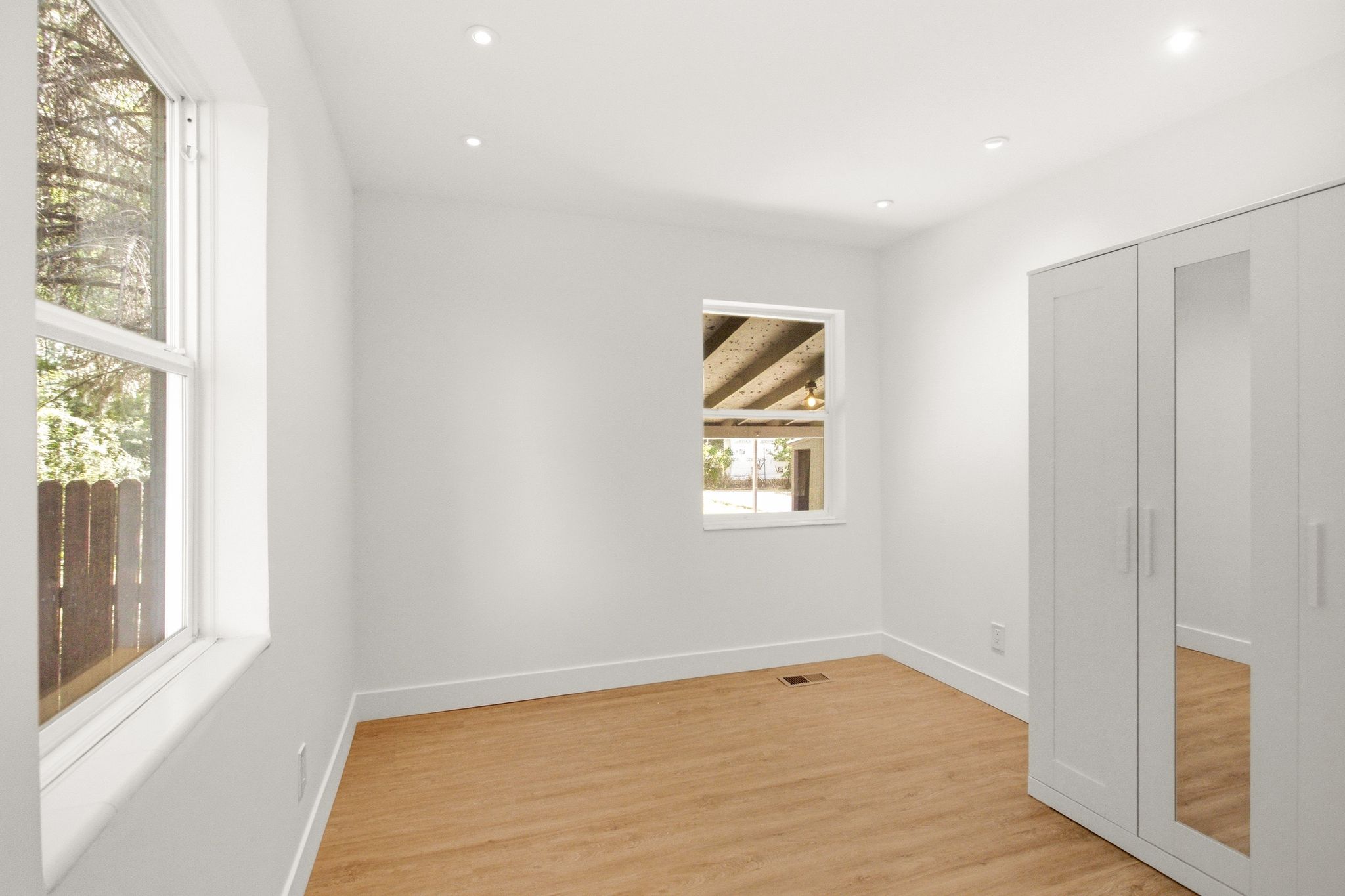 White-painted interior room featuring recessed lighting, light wood-finish flooring, and white baseboards
