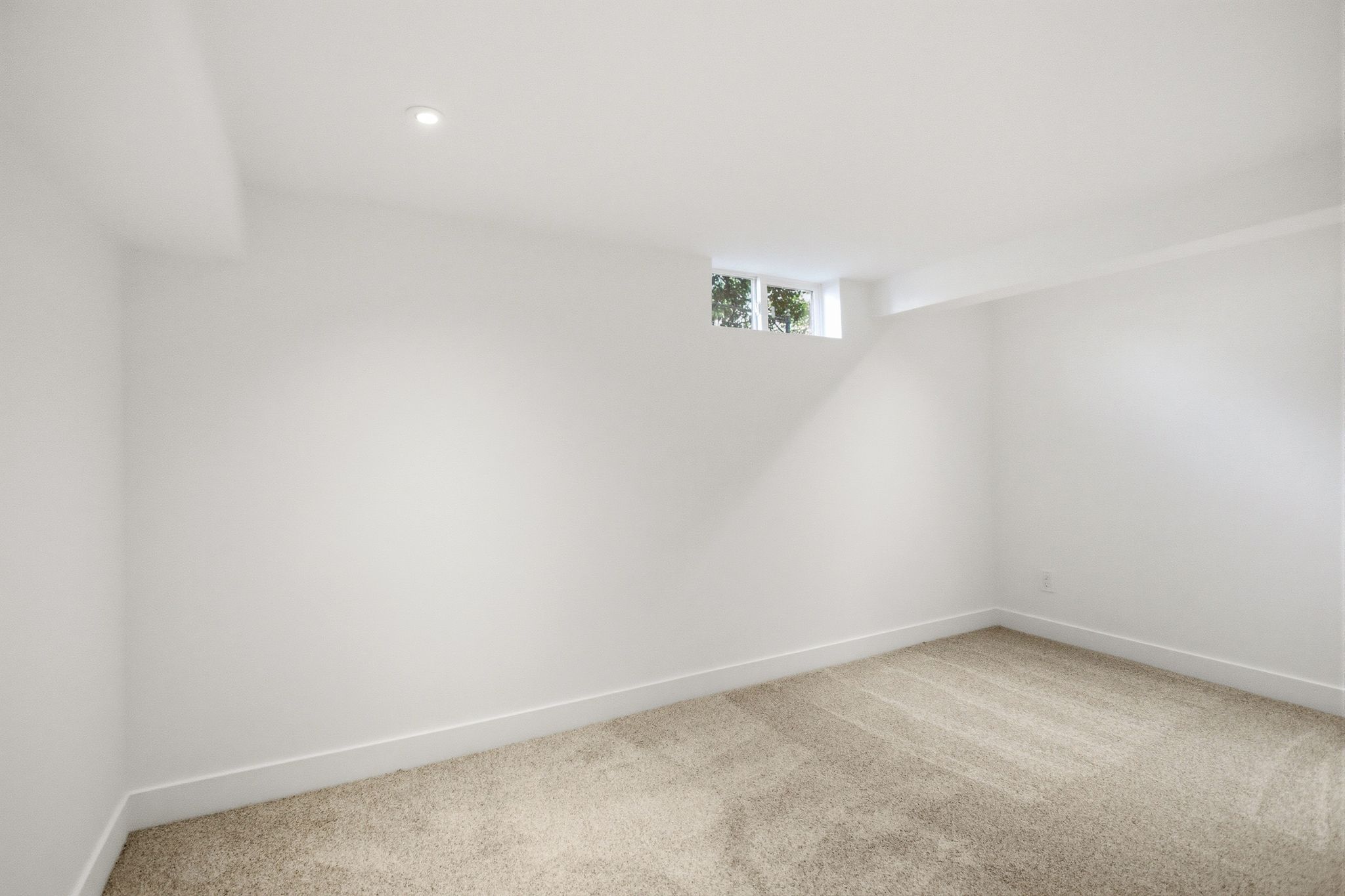 Neutral carpet flooring with white baseboards and walls