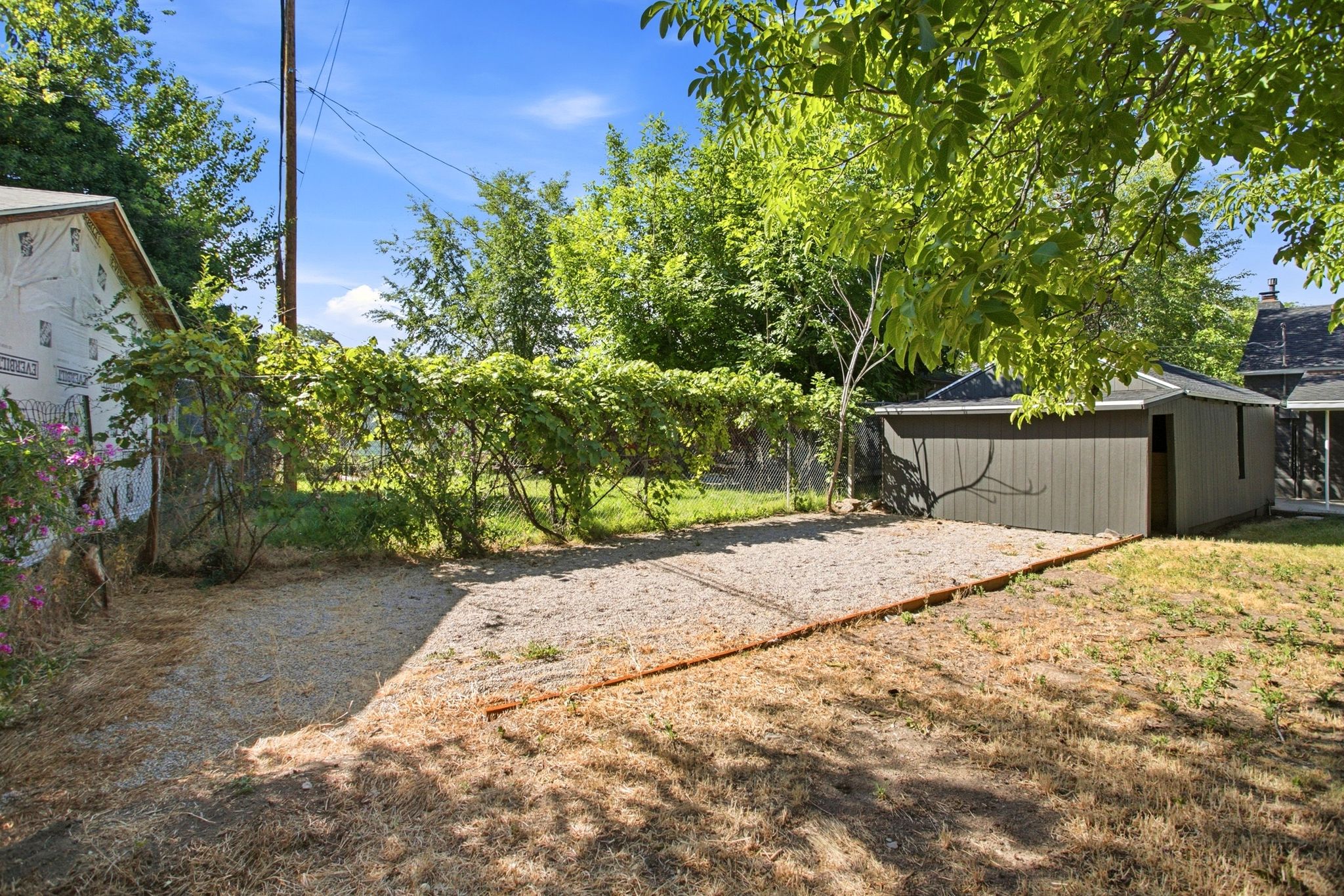 Detached shed with vertical siding and an asphalt shingle roof