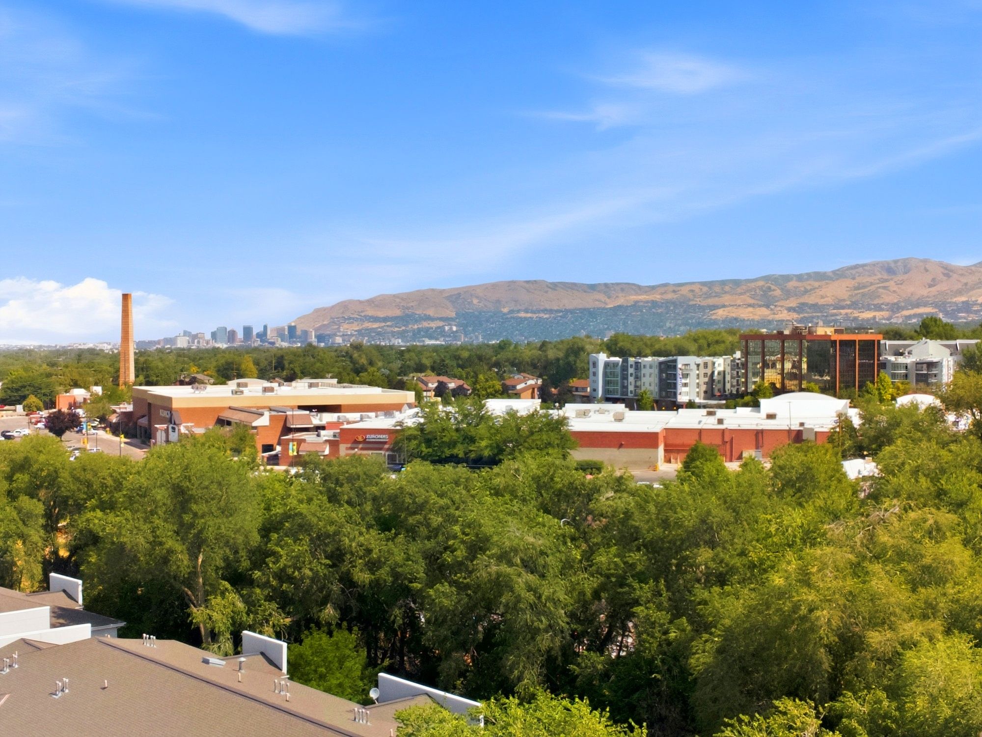 Expansive urban panorama featuring a distant city skyline and surrounding mountain range