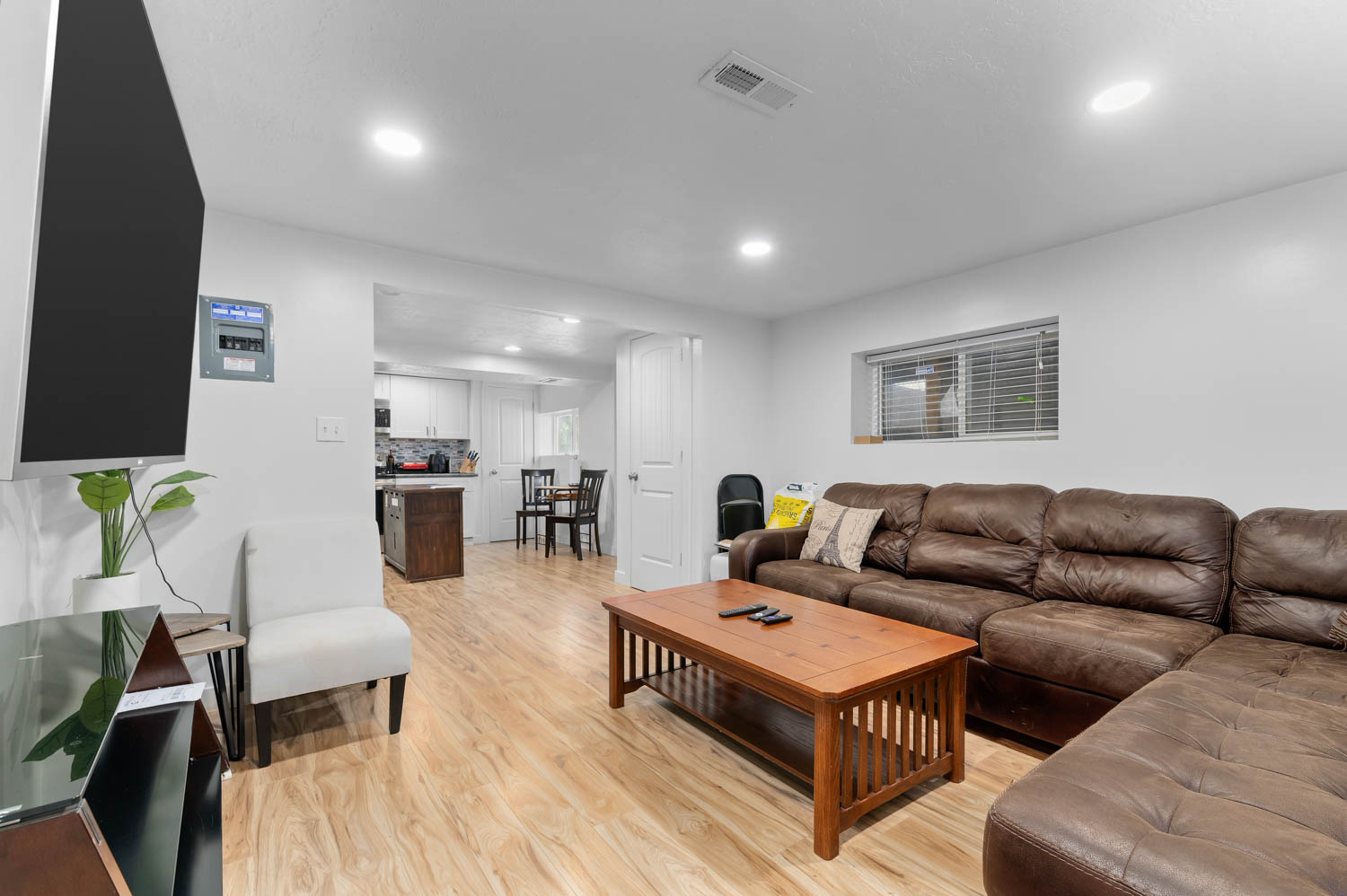 Open-concept living area featuring wood-finish flooring, recessed lighting, and white walls