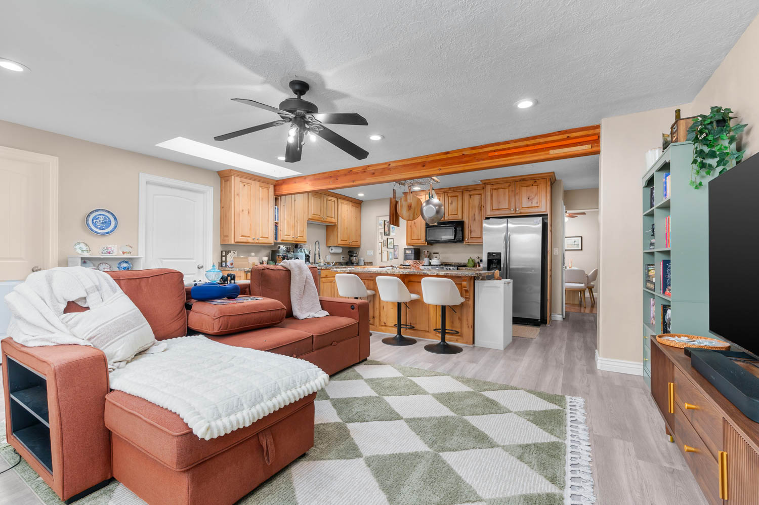 Open-concept living area featuring light wood-finish flooring, a contemporary ceiling fan, and recessed lighting