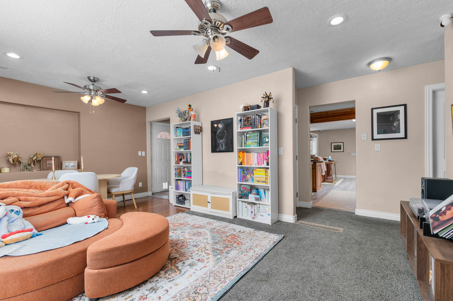 Open-concept living space featuring wood-finish flooring, recessed lighting, and ceiling fans