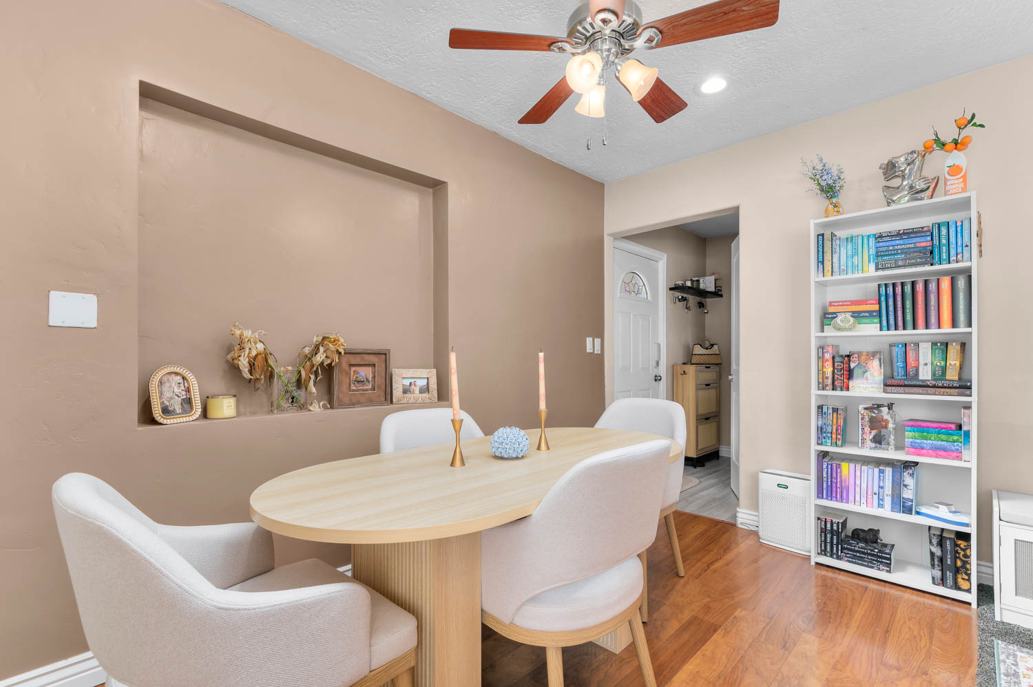 Recessed wall niche, hard-surface flooring, ceiling fan with integrated lighting, built-in shelving, and neutral wall tones