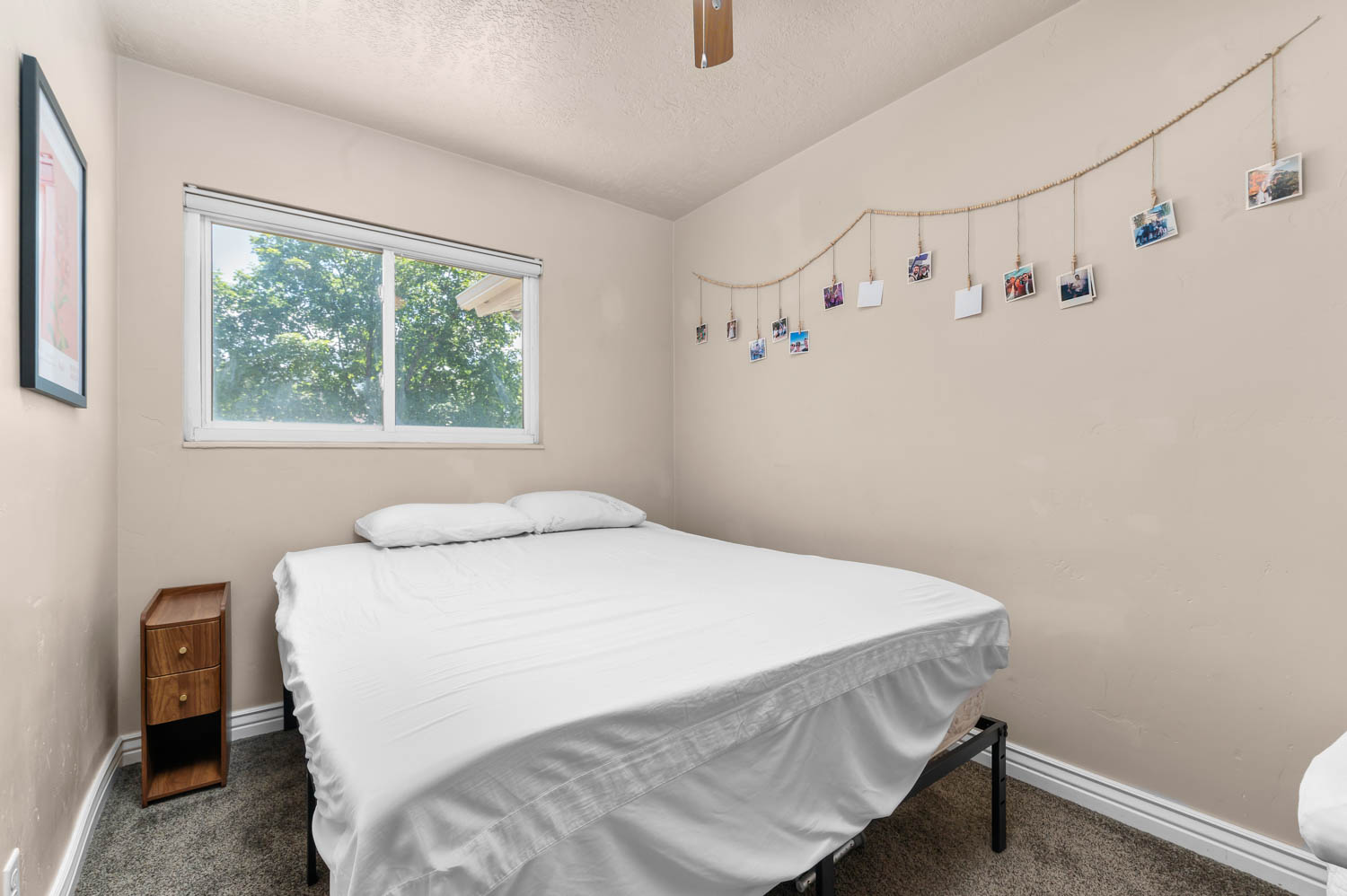 Bedroom featuring neutral wall tones, gray carpeting, a single window, and white trim