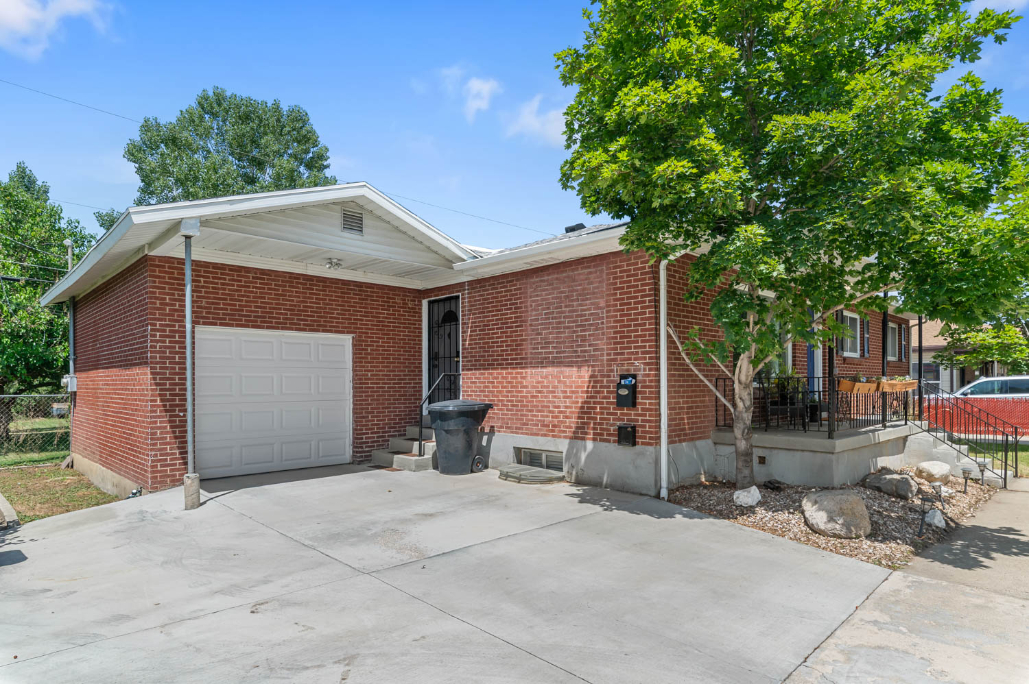 Brick exterior home featuring a covered front entry, concrete driveway, and an attached garage with a white panel door