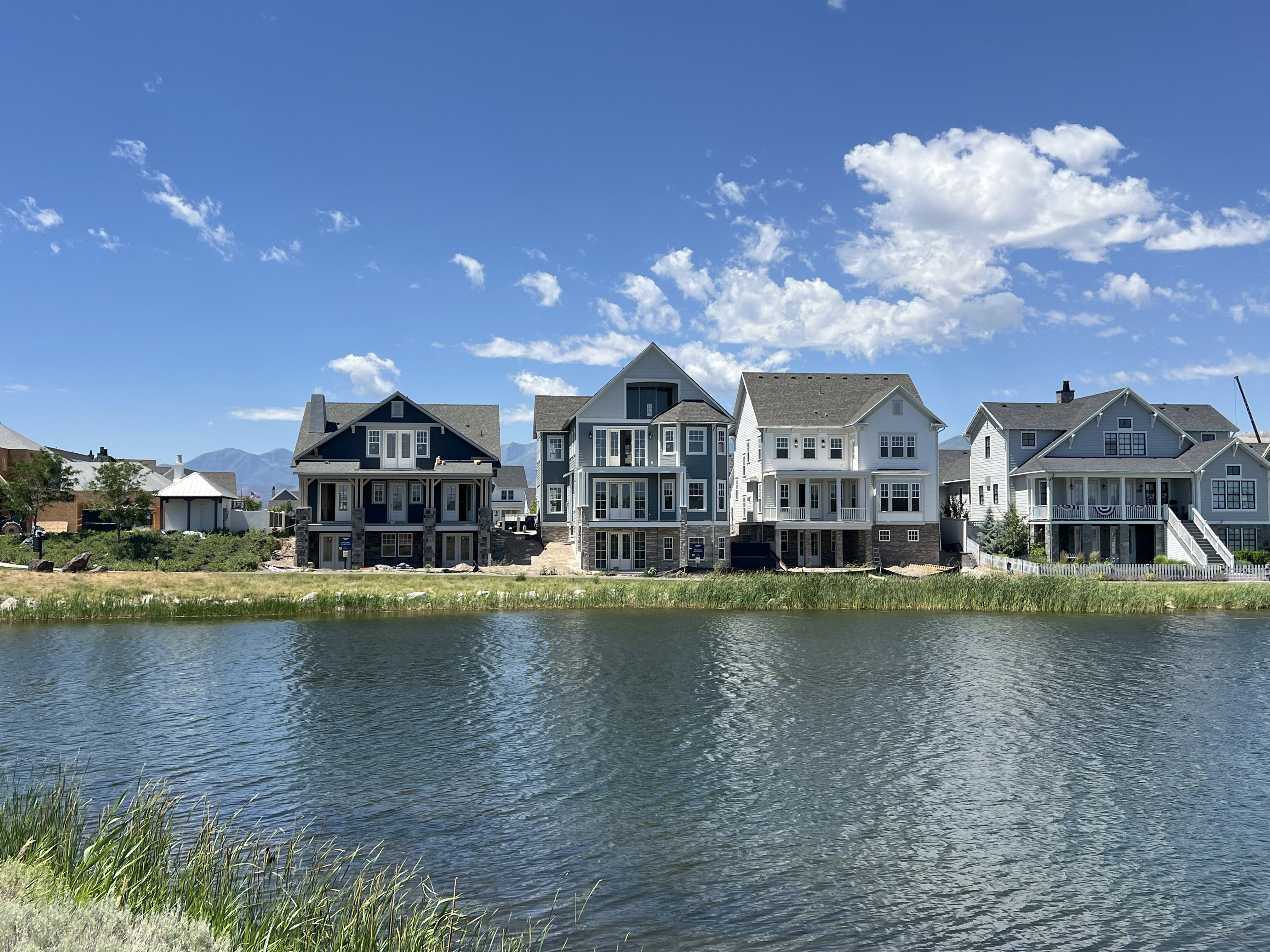 Waterfront properties featuring multi-story facades, covered porches, and mountain scenery