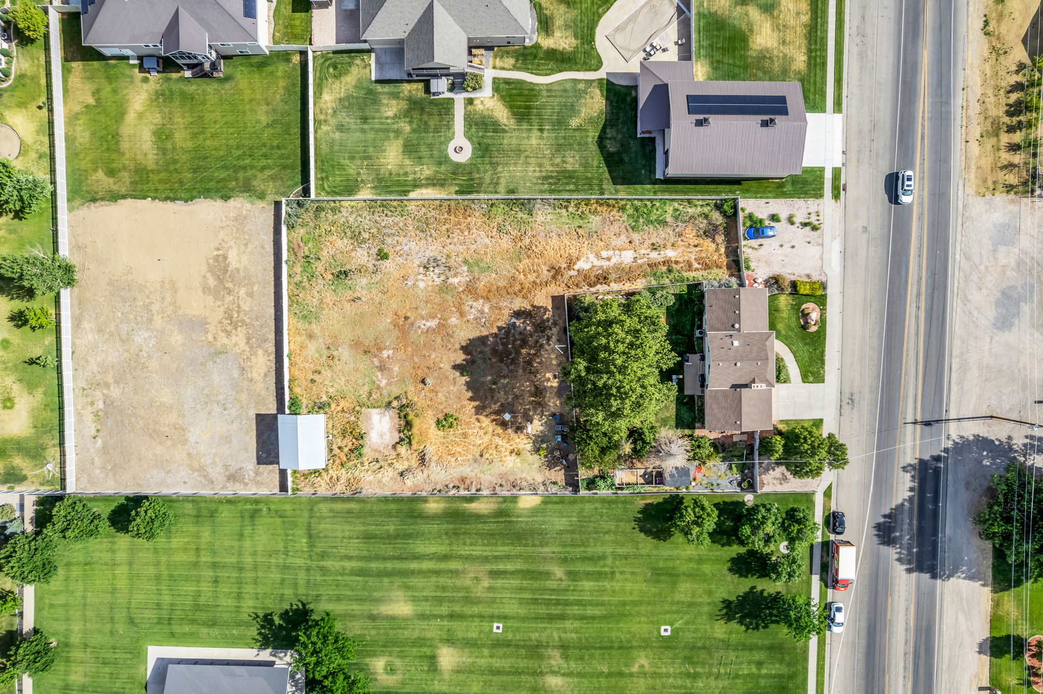 Expansive lot featuring a small outbuilding and adjacent street access